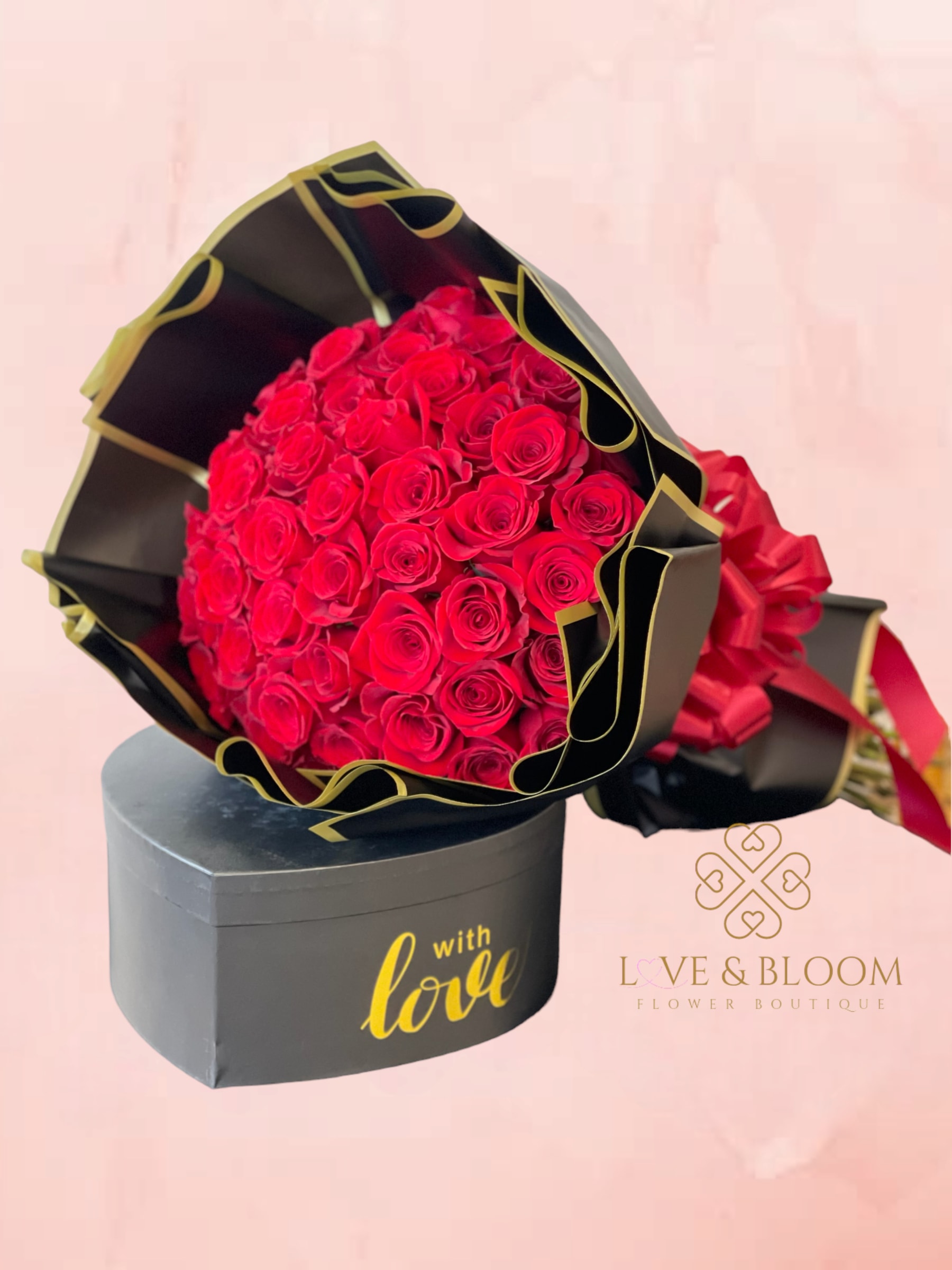Bouquet of red roses in black and gold wrapping with a gift box