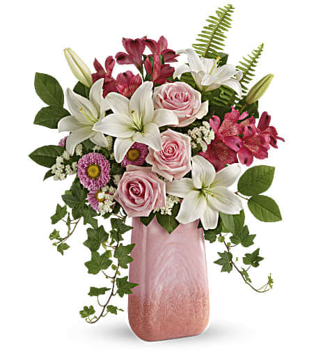 Pink and white floral arrangement in a tall pink vase