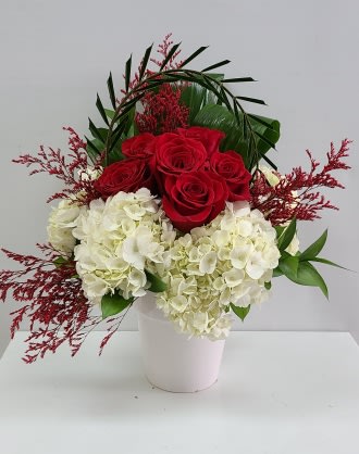 Red roses and white hydrangeas in a white vase