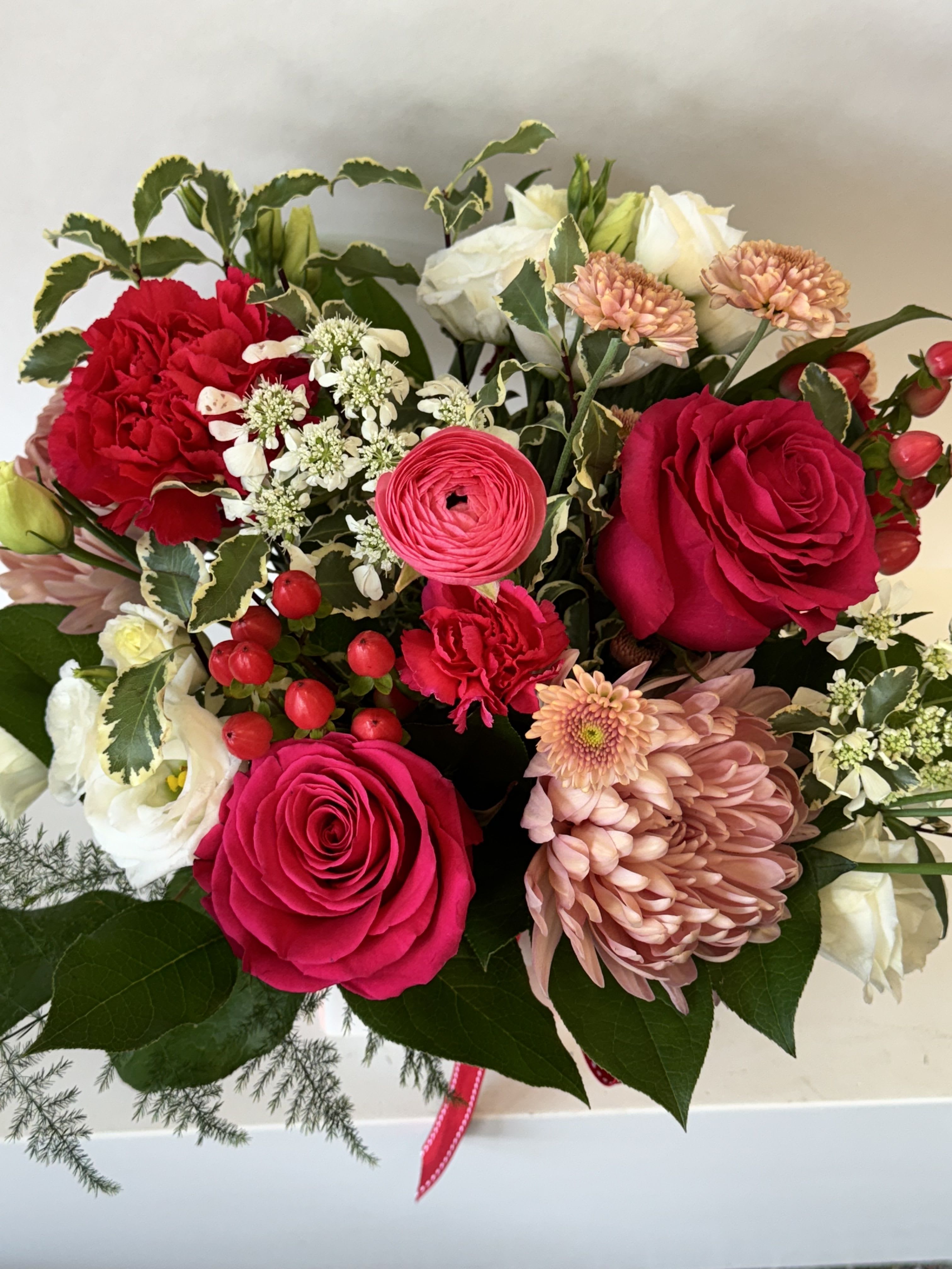 Bouquet of red and white roses with pink chrysanthemums and berries