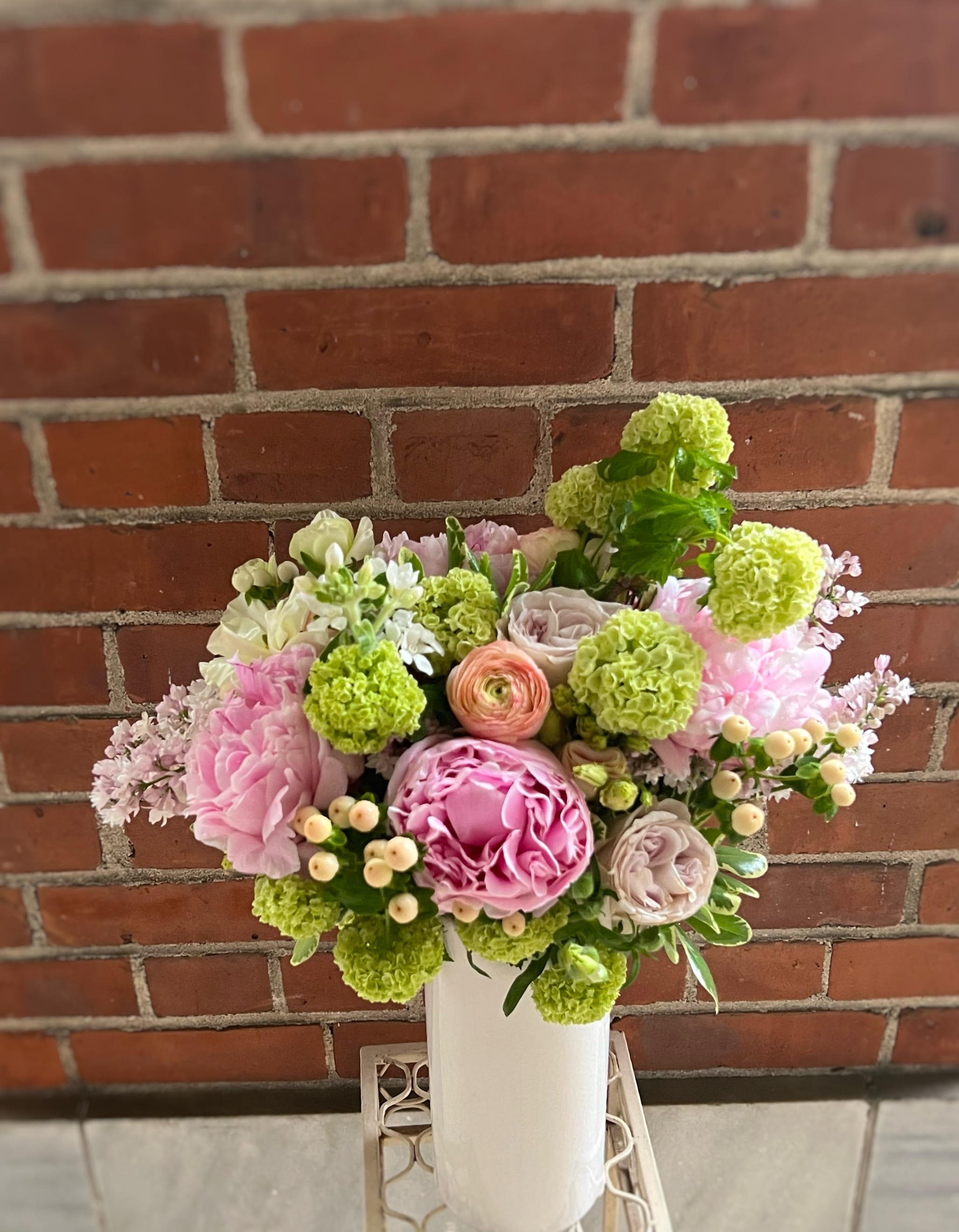 Pink and green floral arrangement in a white vase