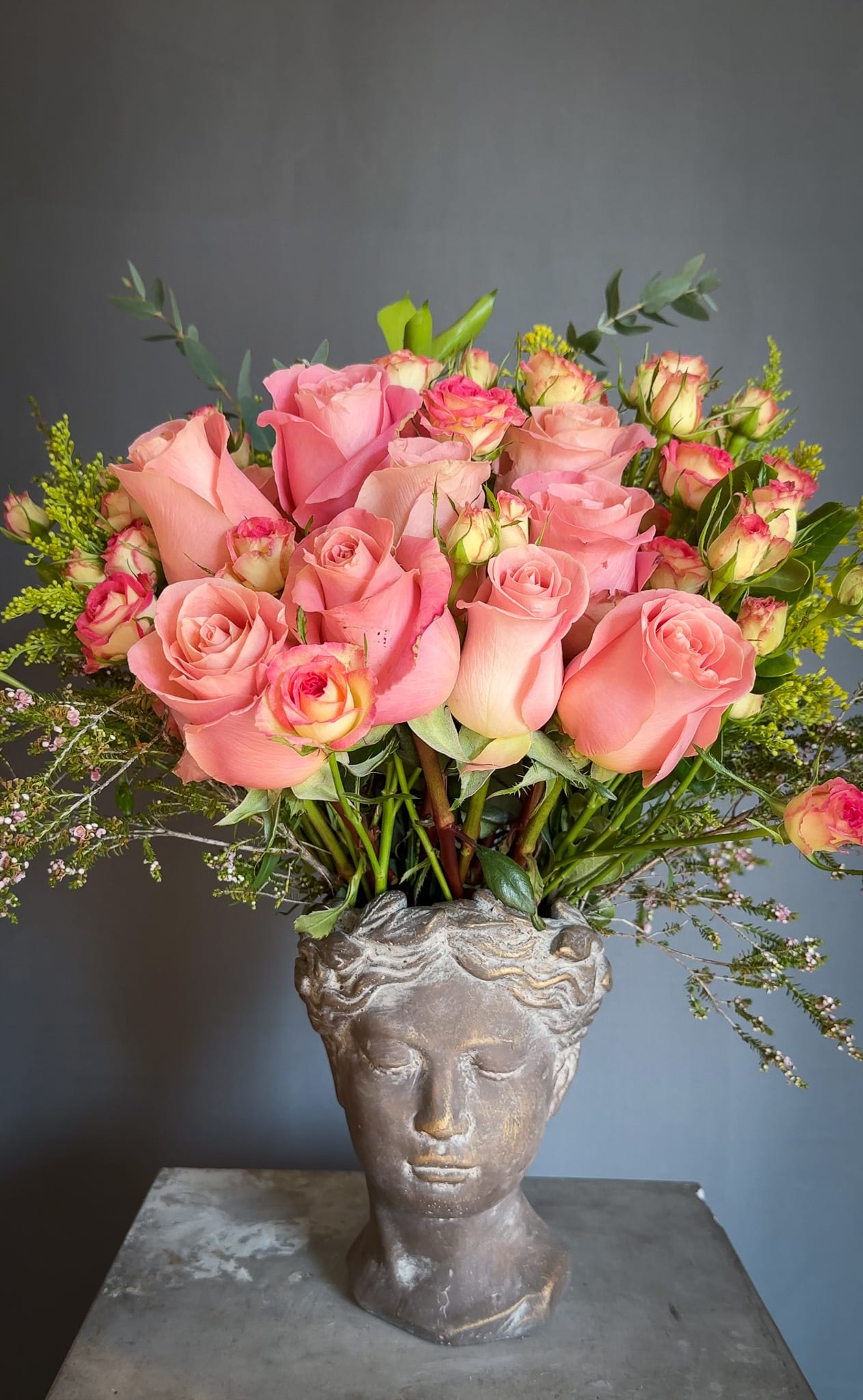 Pink roses arranged in a sculpted head vase