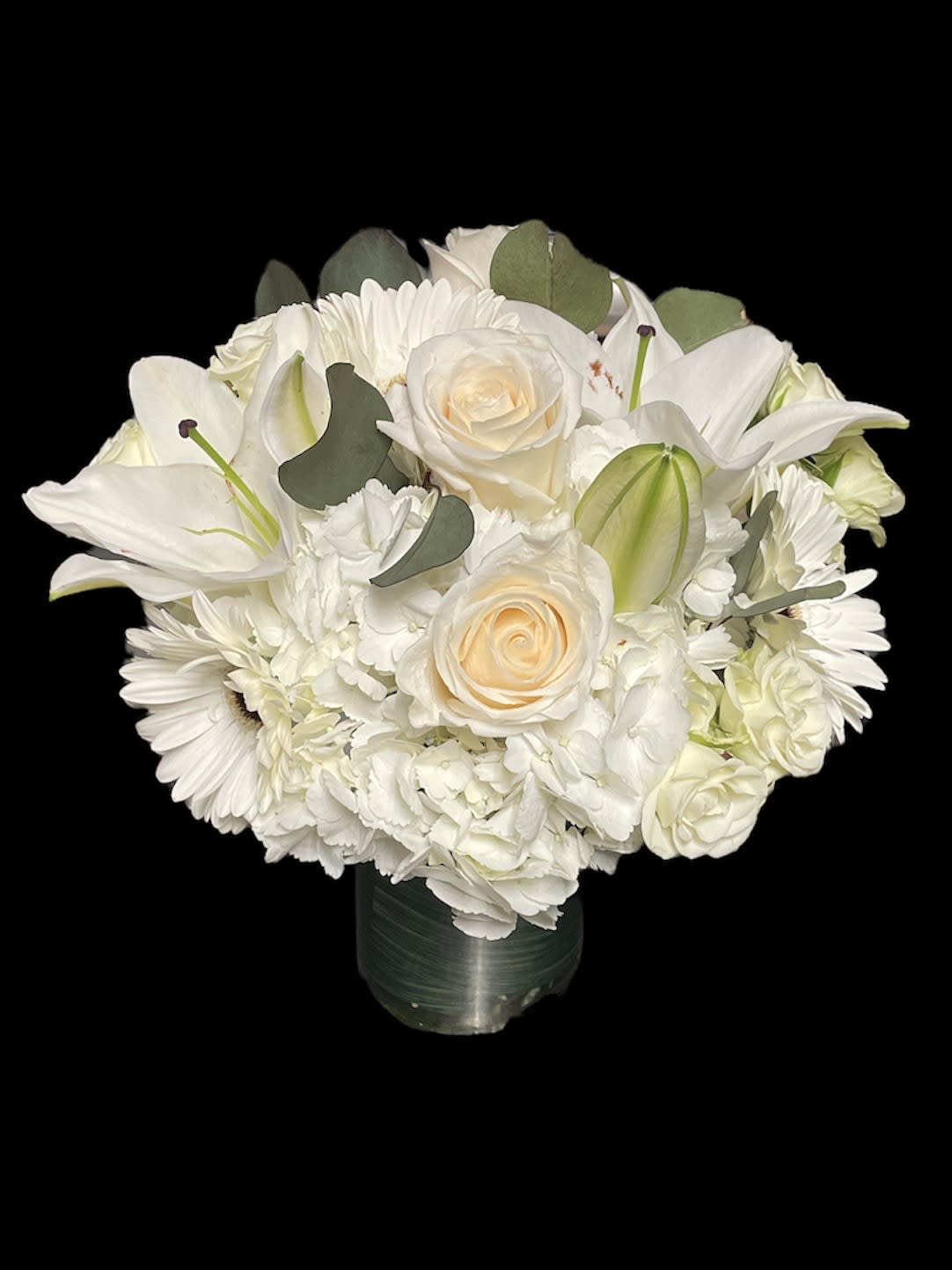 White floral bouquet with roses, lilies, and daisies in a vase