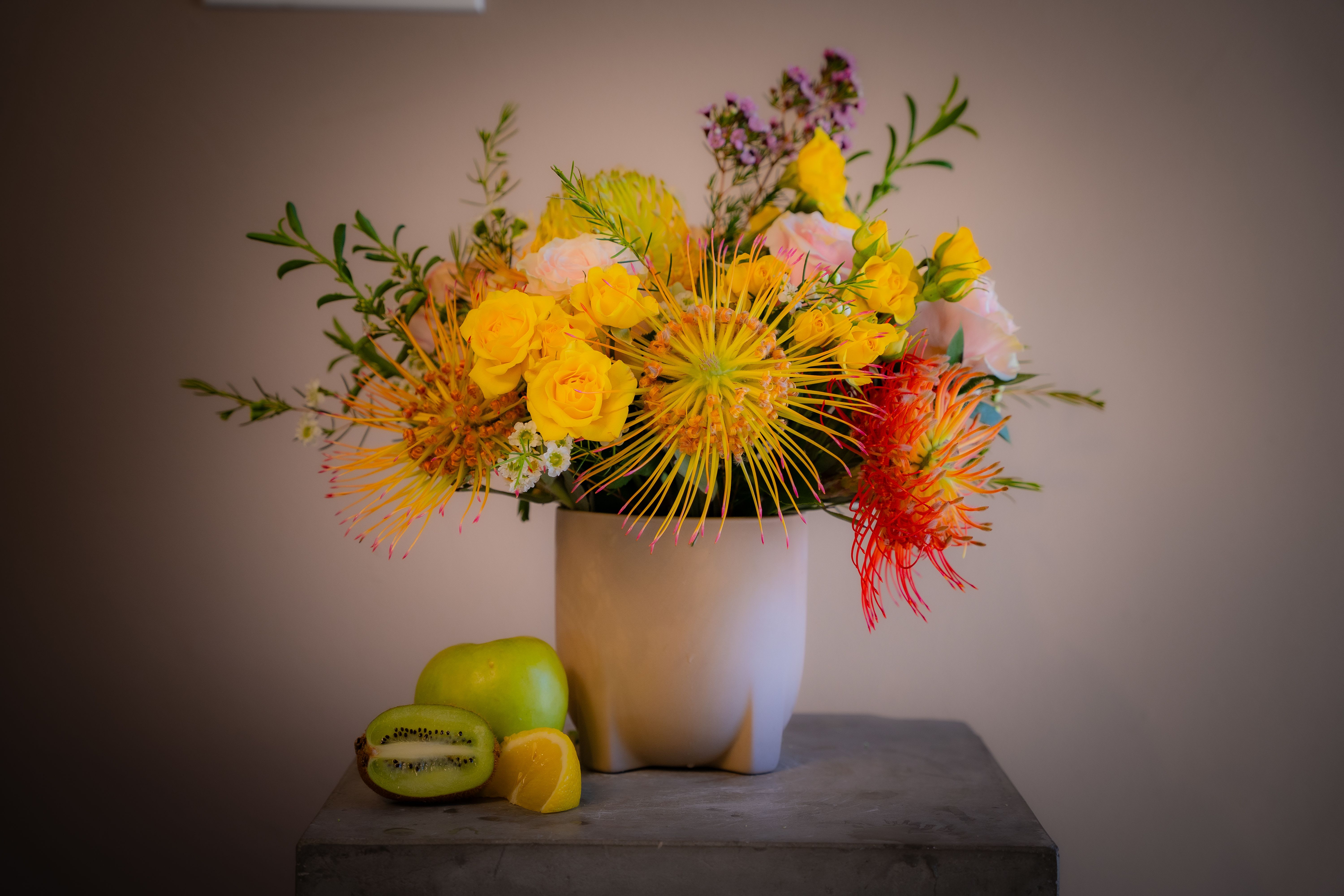 Vicenda Tropicale (Editor's Choice) - Vicenda Tropicale, or "Tropical Affair," is one of our new favorite designs with a soft tropical feel. Featuring garden spirit roses, multi-colored protea, vibrant freesia, and more, this stunning arrangement is beautifully presented in a rustic 6x6 wooden box. Perfect for any occasion, this tropical-inspired design will bring a touch of paradise to your loved ones. Order now for quick and reliable delivery!