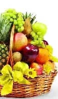 Fruit basket with apples, grapes, and yellow flowers in a wicker basket