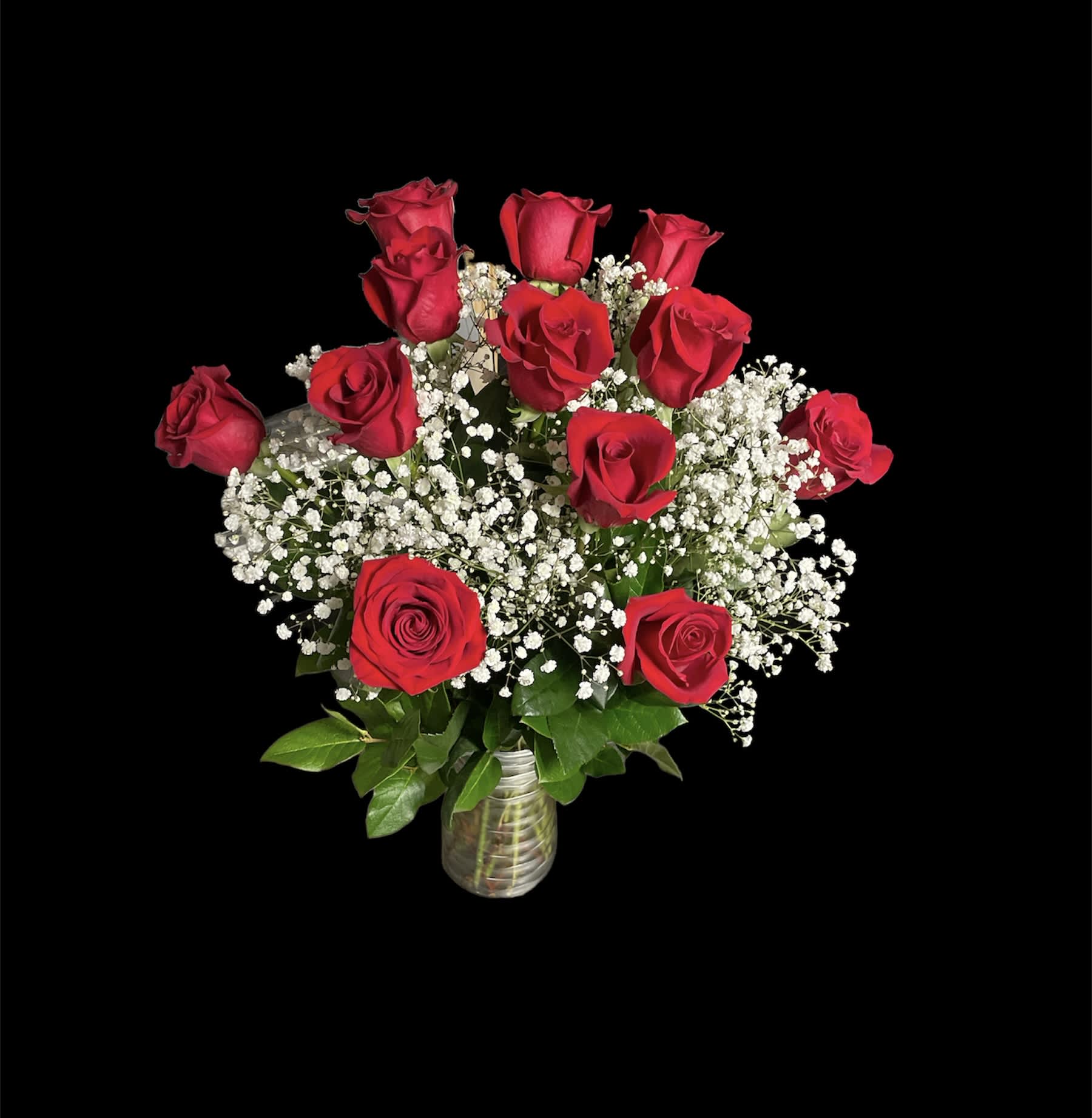 Bouquet of red roses and white baby's breath in a glass vase