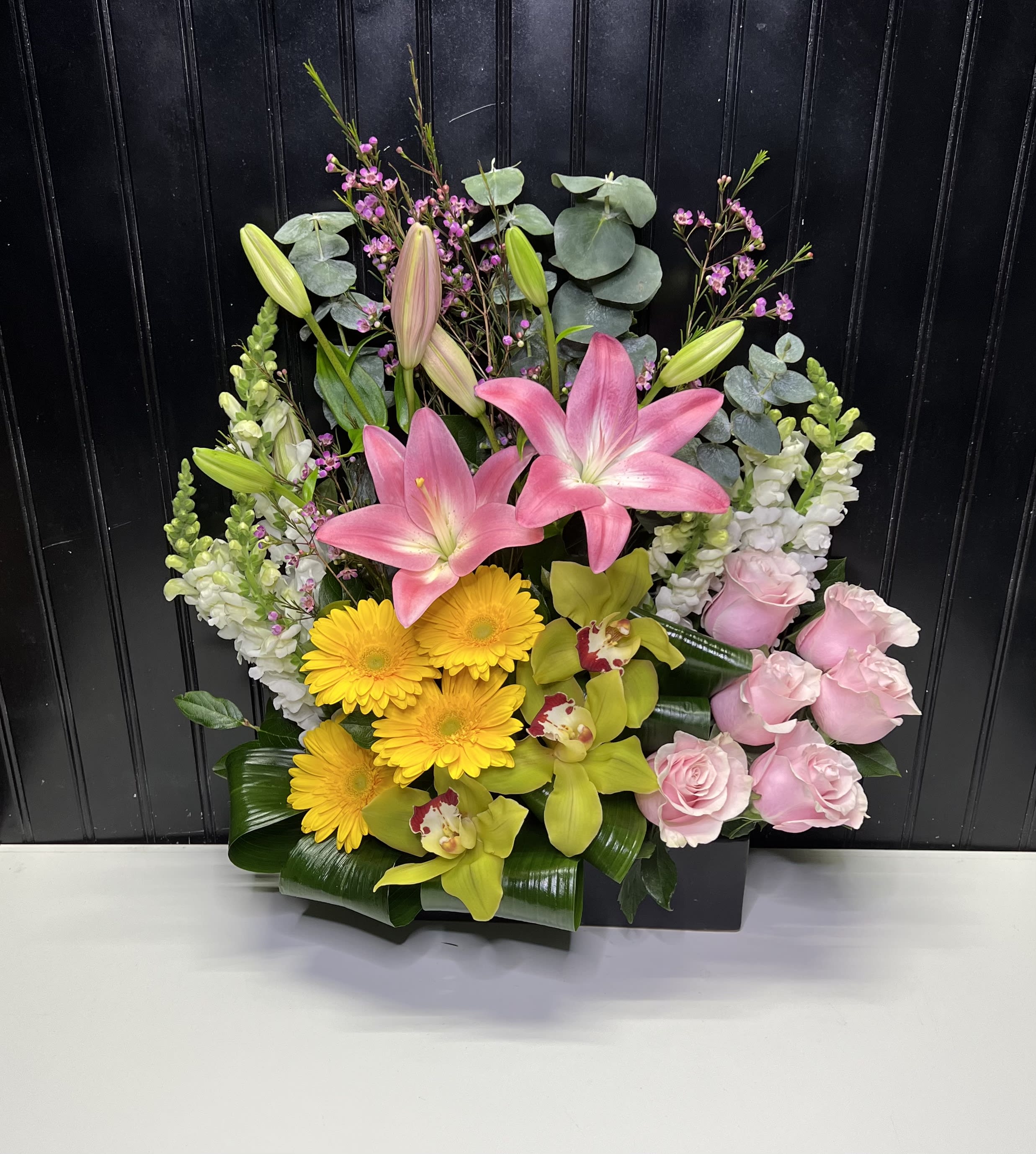 Mixed floral arrangement with pink lilies, yellow gerberas, and pink roses