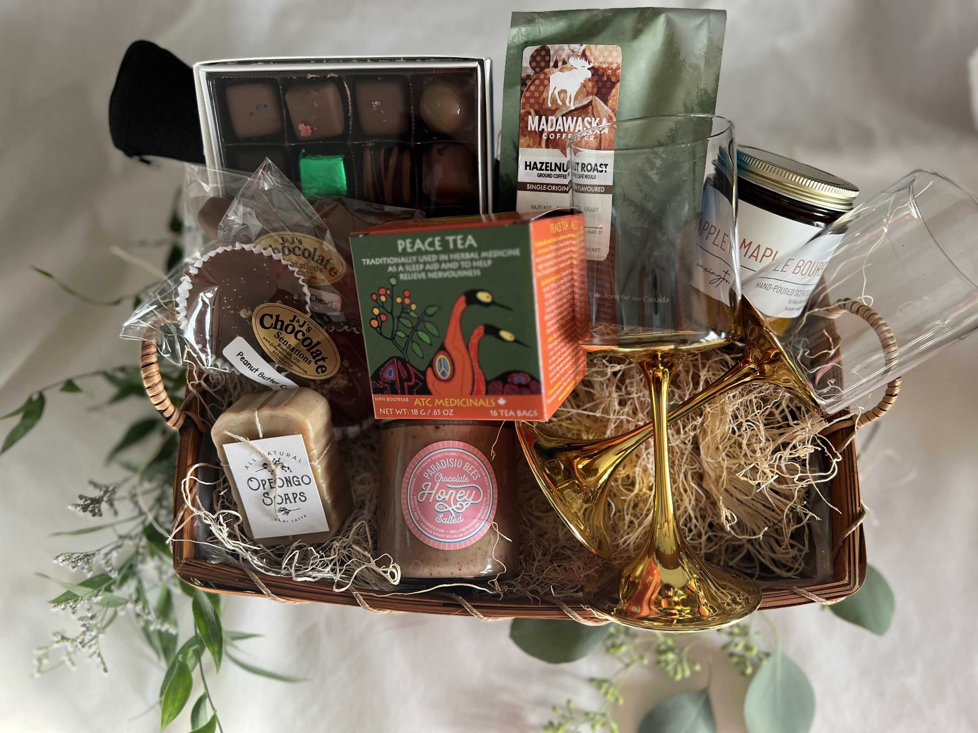 Gift basket with chocolates, tea, coffee, soap, honey, and two gold glasses