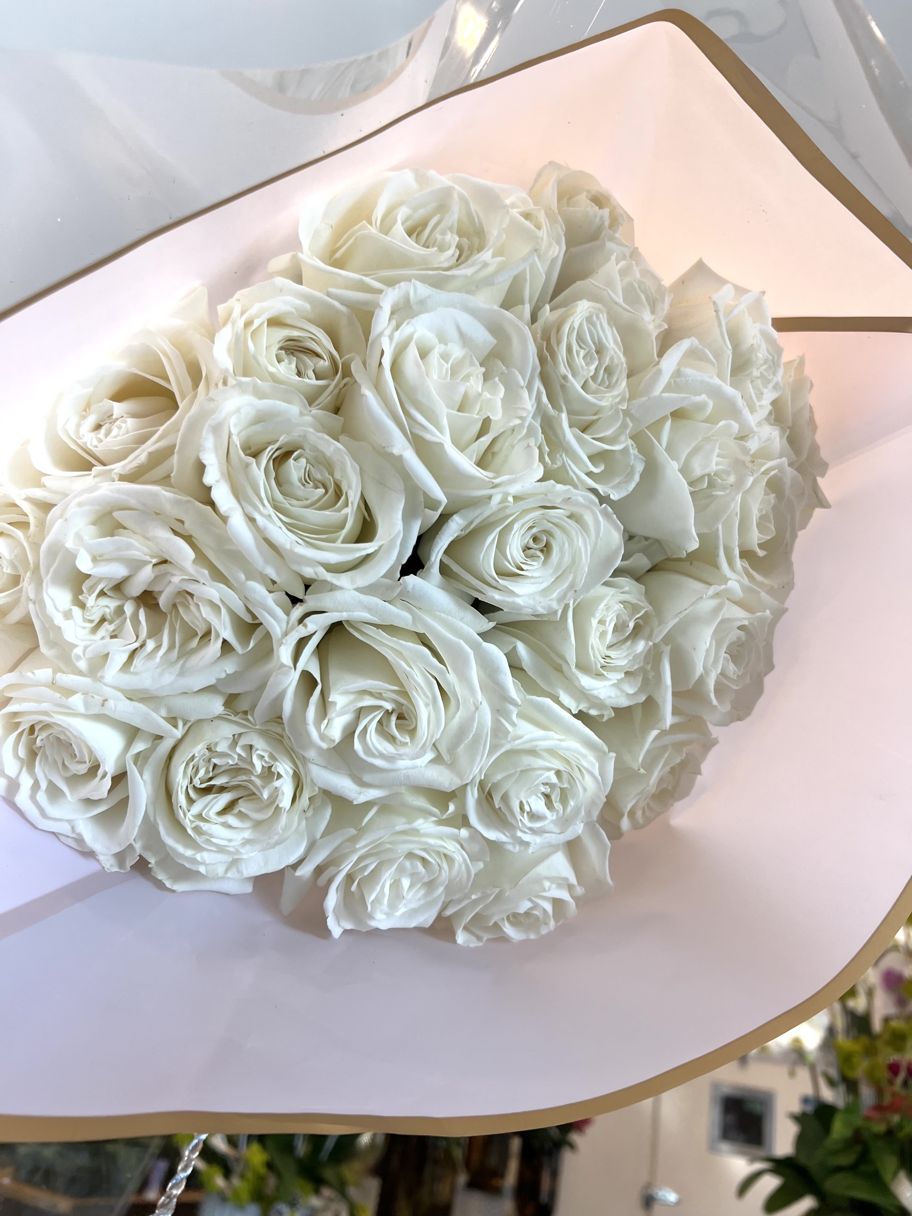 Bouquet of white roses wrapped in pale pink paper
