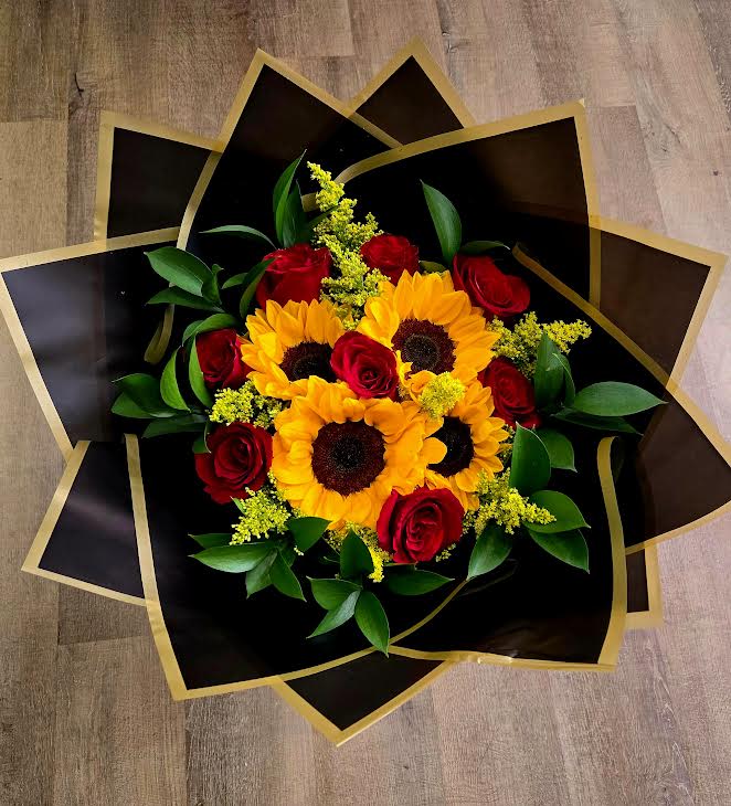 Bouquet of red roses and yellow sunflowers in black and gold wrap