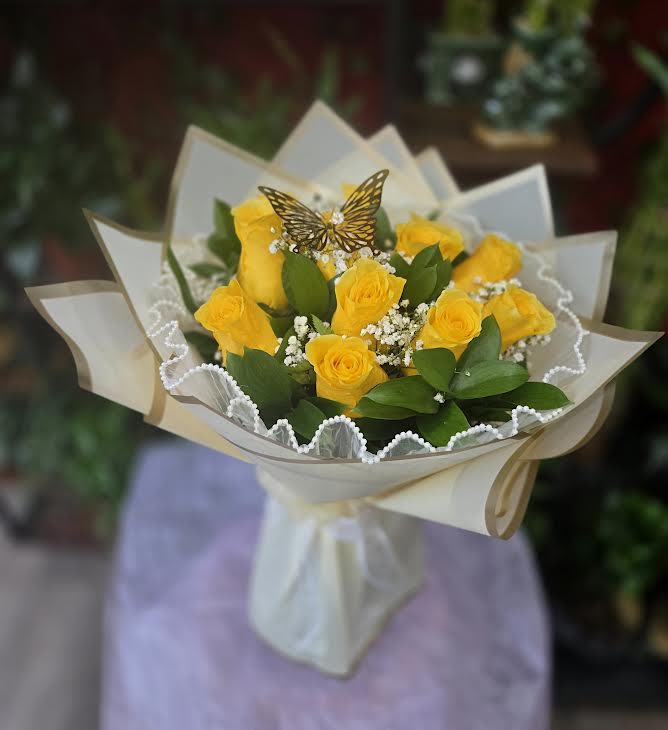 Bouquet of yellow roses wrapped in cream paper