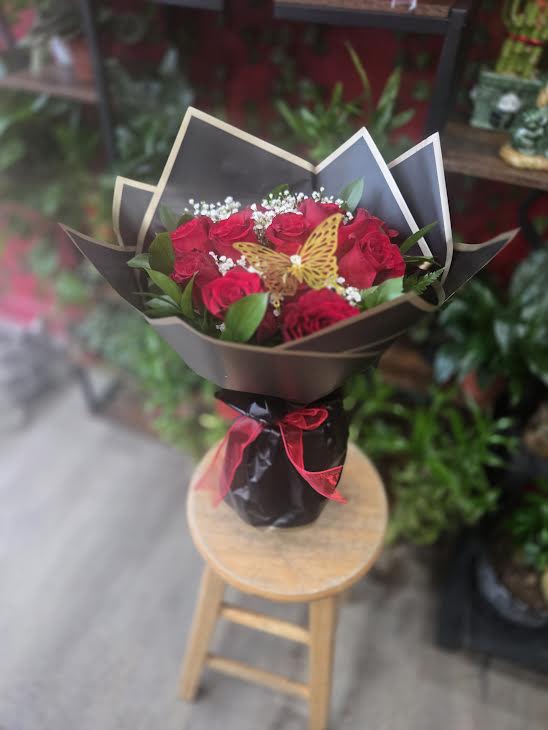 Bouquet of red roses with a butterfly decoration in black wrap