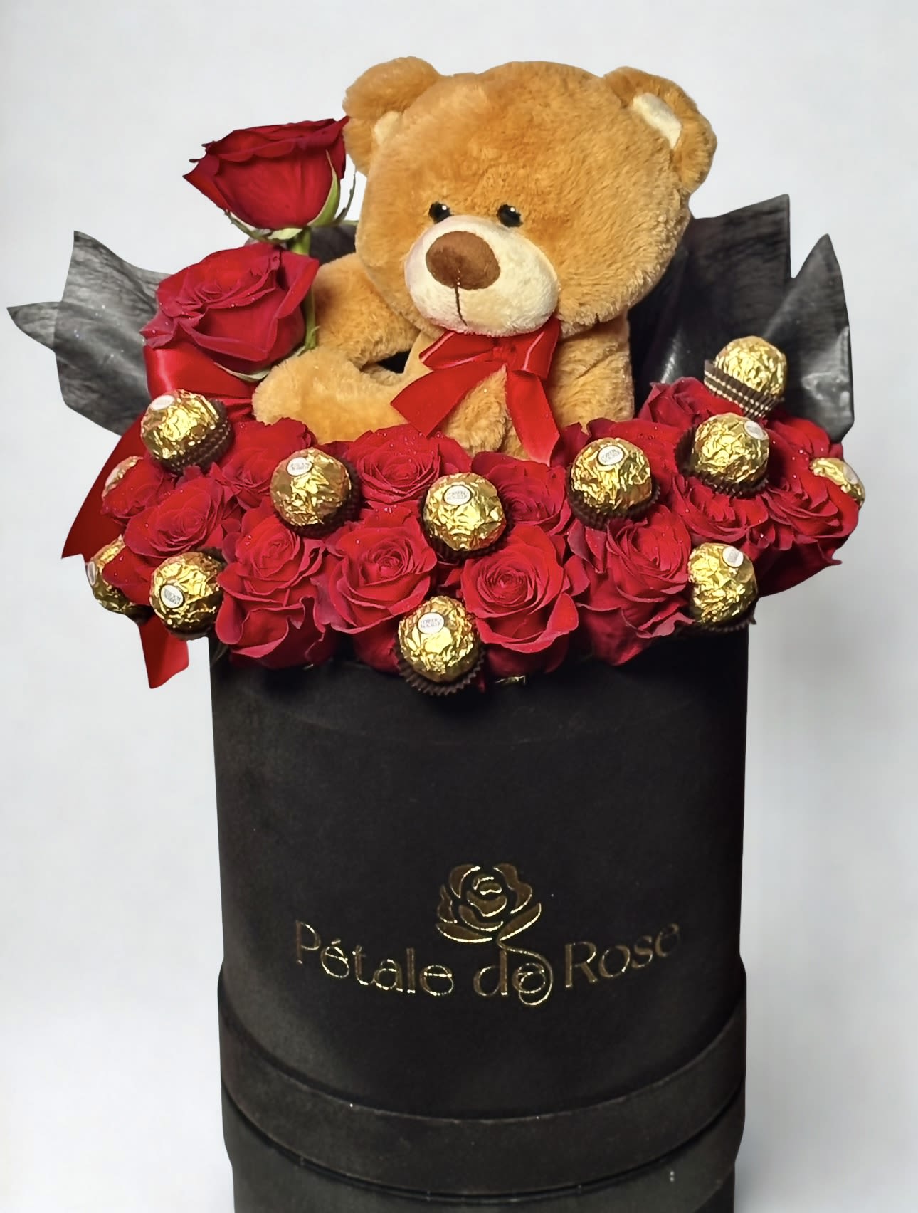  Sweet Teddy Box  - This elegant black box features 10 fresh red roses, beautifully arranged with luxury chocolates and a soft teddy bear, creating the perfect balance of romance and sweetness. An ideal gift to express love, and affection in a charming way.   Includes: • fresh red roses • Ferrero chocolates • Teddy bear  • Black floral box  Perfect for Mothers day, Valentine’s Day, anniversaries, or a surprise. 
