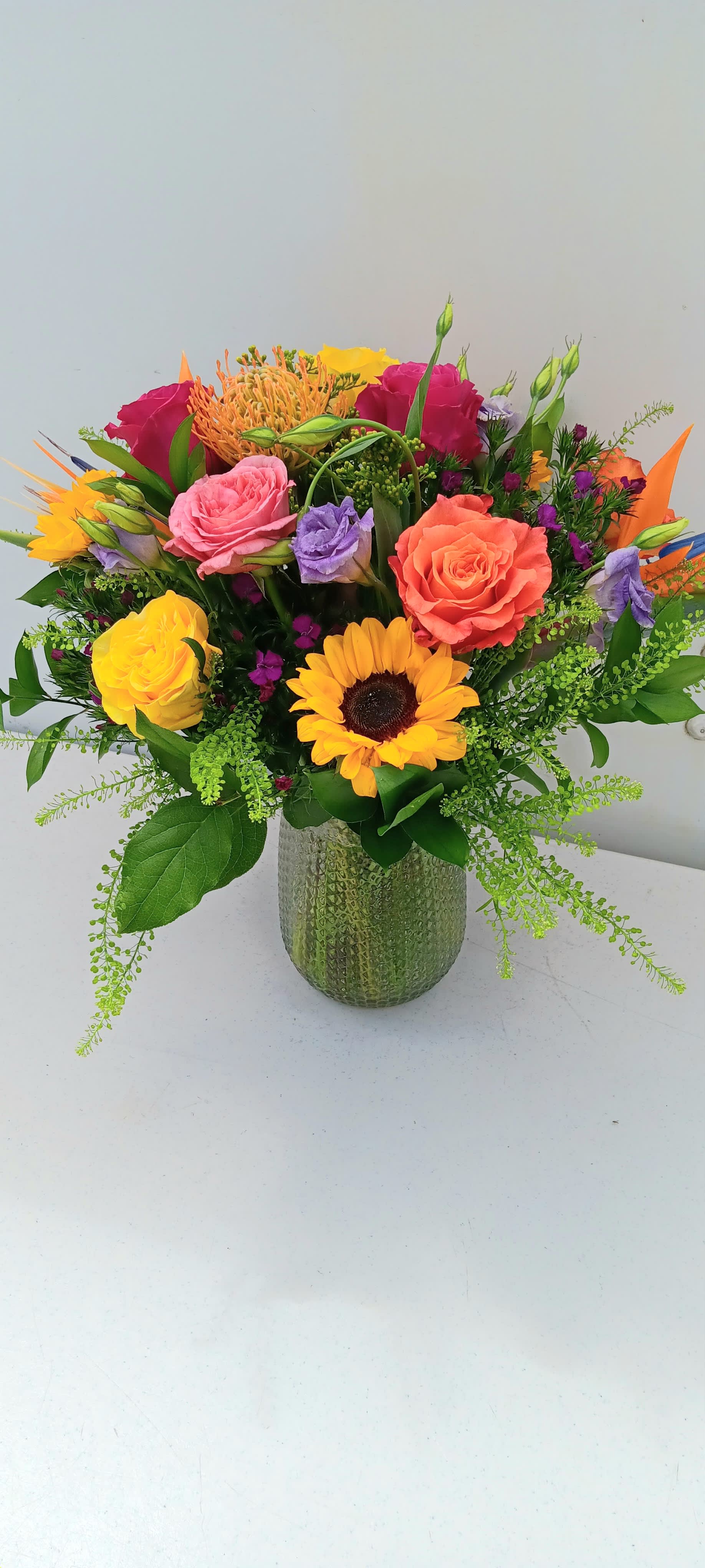 Colorful mixed bouquet in a textured glass vase