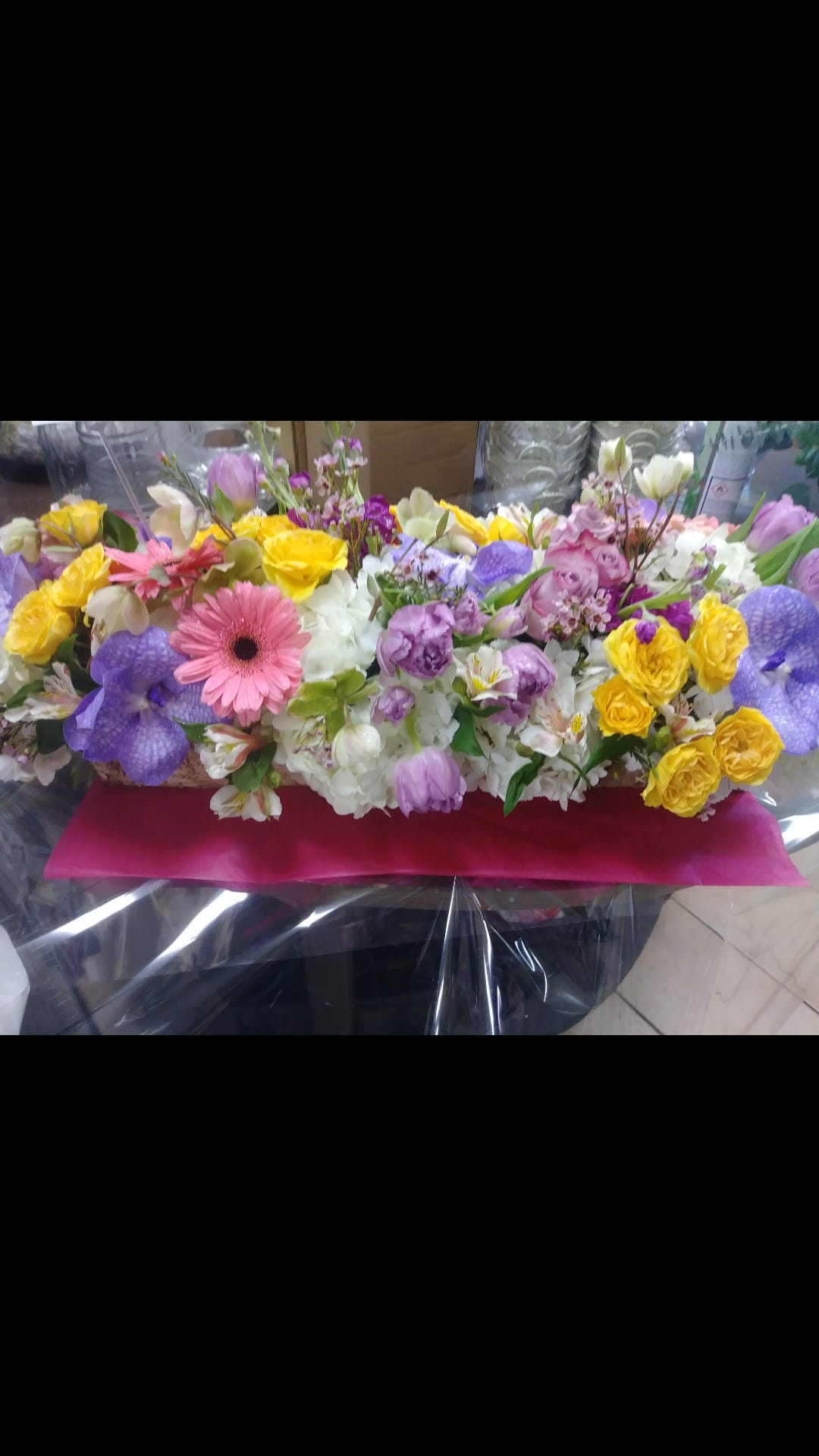 Mixed bouquet with yellow roses, pink gerbera daisies, and purple blooms