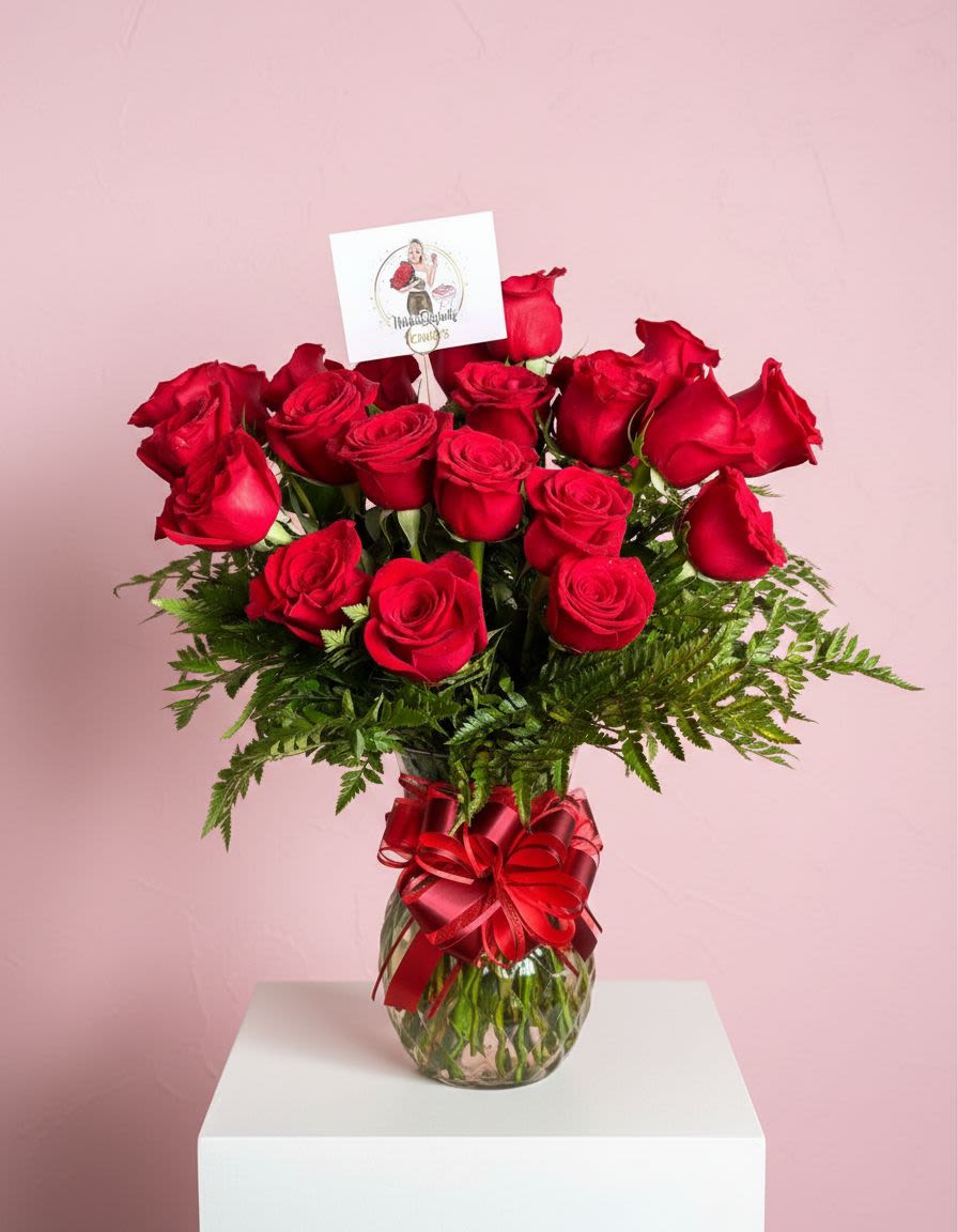 Red roses in a glass vase with a red ribbon bow