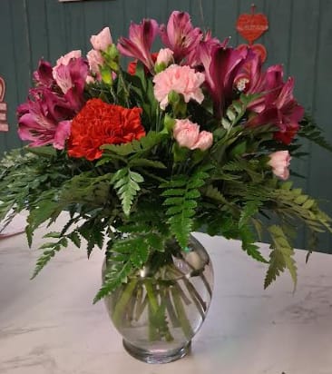 Pink and red mixed bouquet in a clear glass vase