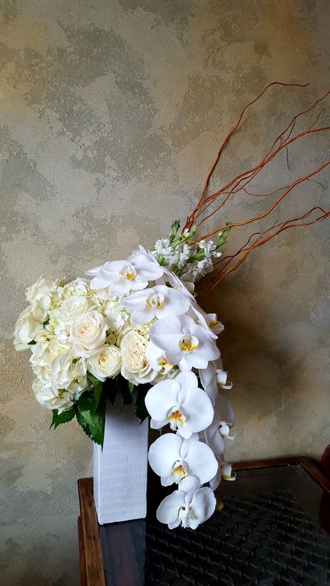 White floral arrangement with cascading orchids in a vase