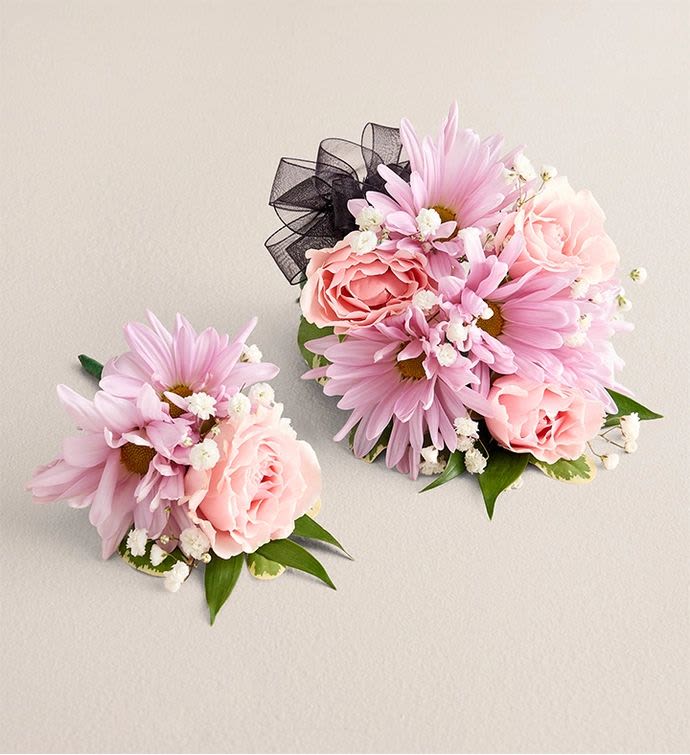 Corsage &amp; Boutonniere  - Soft pink daisies and blush roses paired with tiny white filler blossoms create a delicate, wearable duo perfect for a wedding, prom, quinceañera, or any formal dance. This corsage and boutonniere set delivers a romantic, pastel look that makes the person wearing it feel cherished and celebrated-soft textures and gentle colors read as thoughtful and timeless against formal attire.  The corsage and boutonniere are compact and hand-crafted for a neat, comfortable fit on wrist or lapel. Each piece features daisy-like blooms, blush roses, and small white accents; the corsage is finished with a black tulle ribbon that adds a subtle, elegant contrast to the light palette. Lightweight and secure, these pieces are designed to coordinate beautifully with dresses, suits, and tuxedos for milestone celebrations and special events.