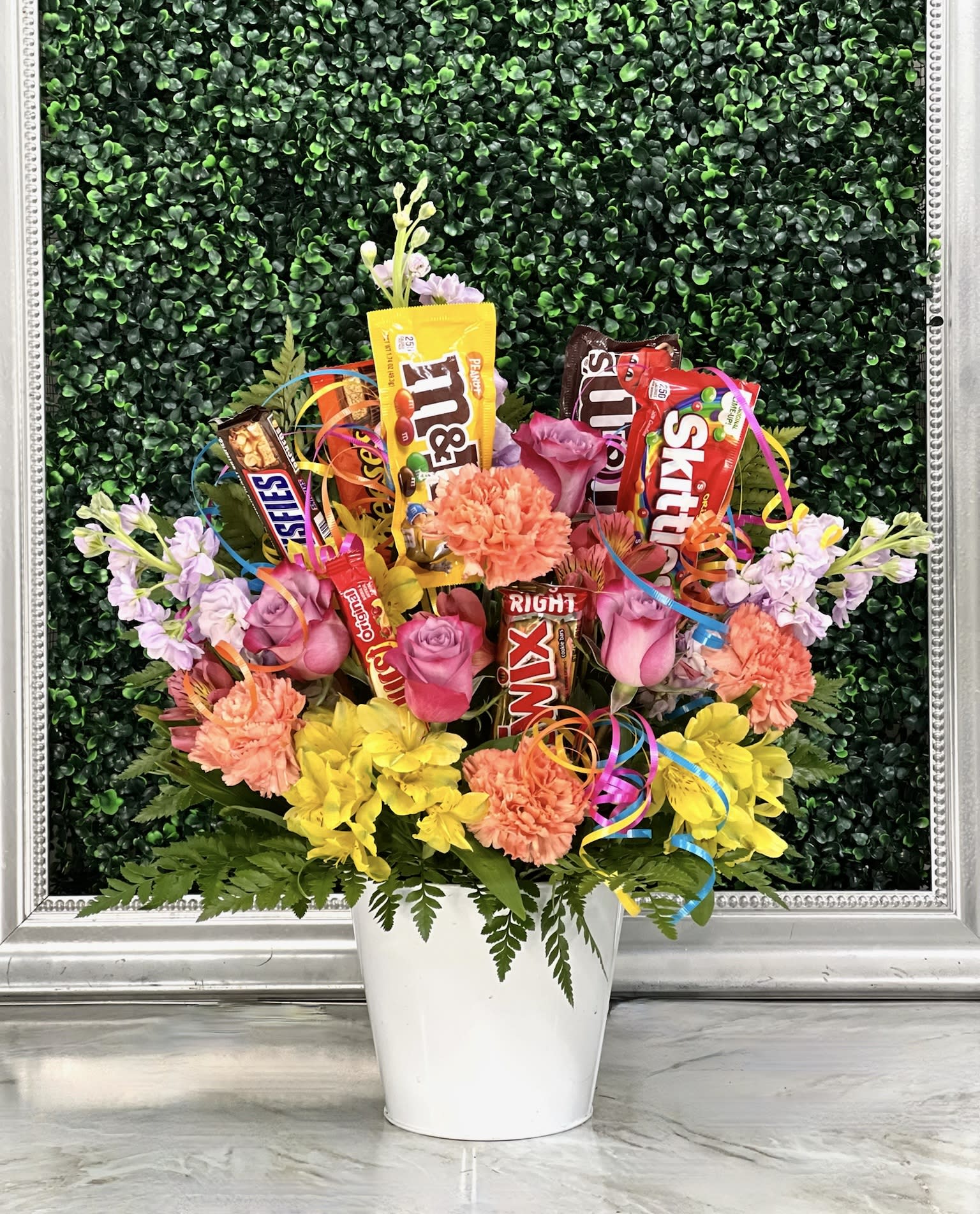 Candy bouquet with pink and yellow flowers in a white pot