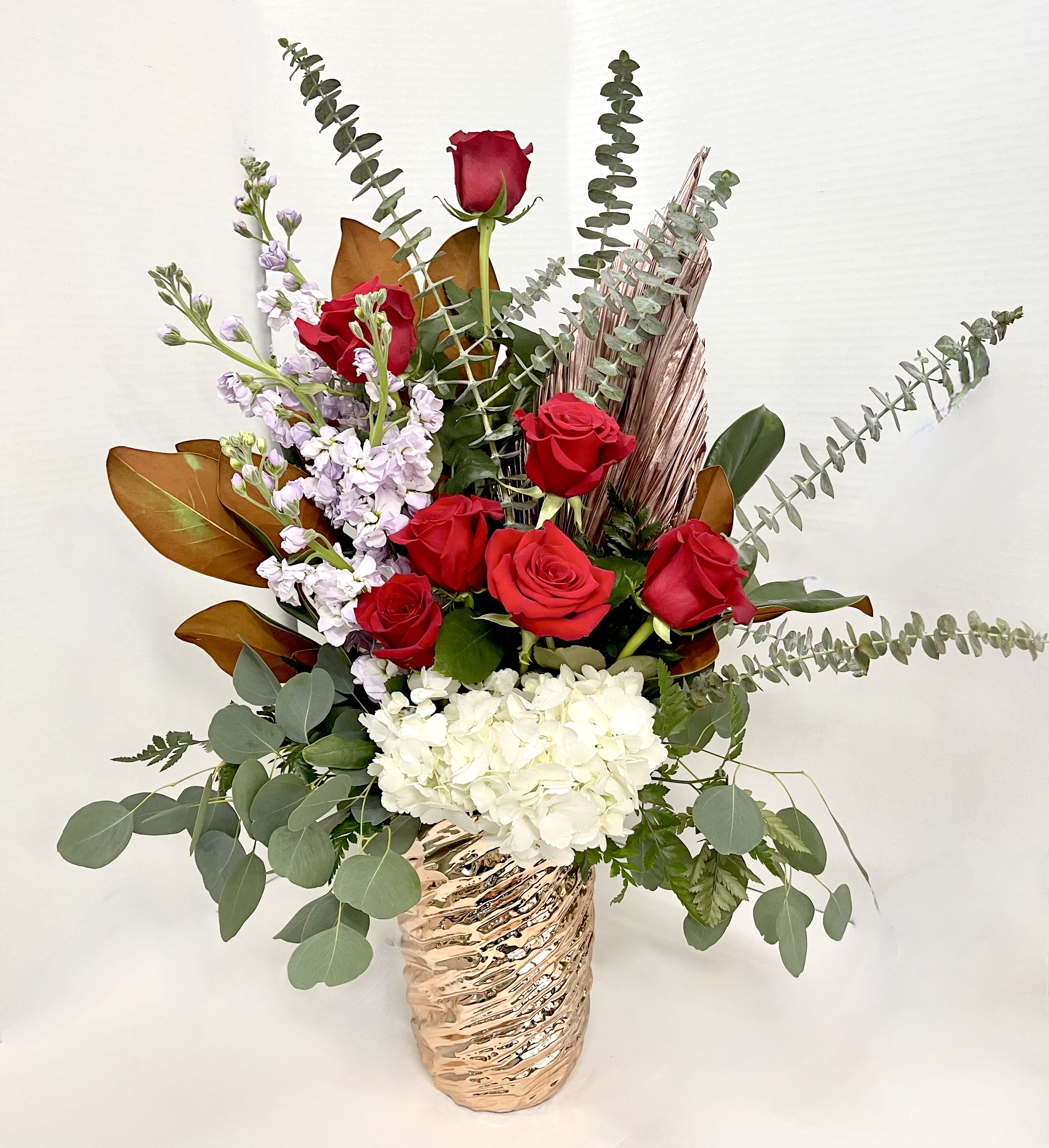 Red roses and white hydrangea in a metallic vase