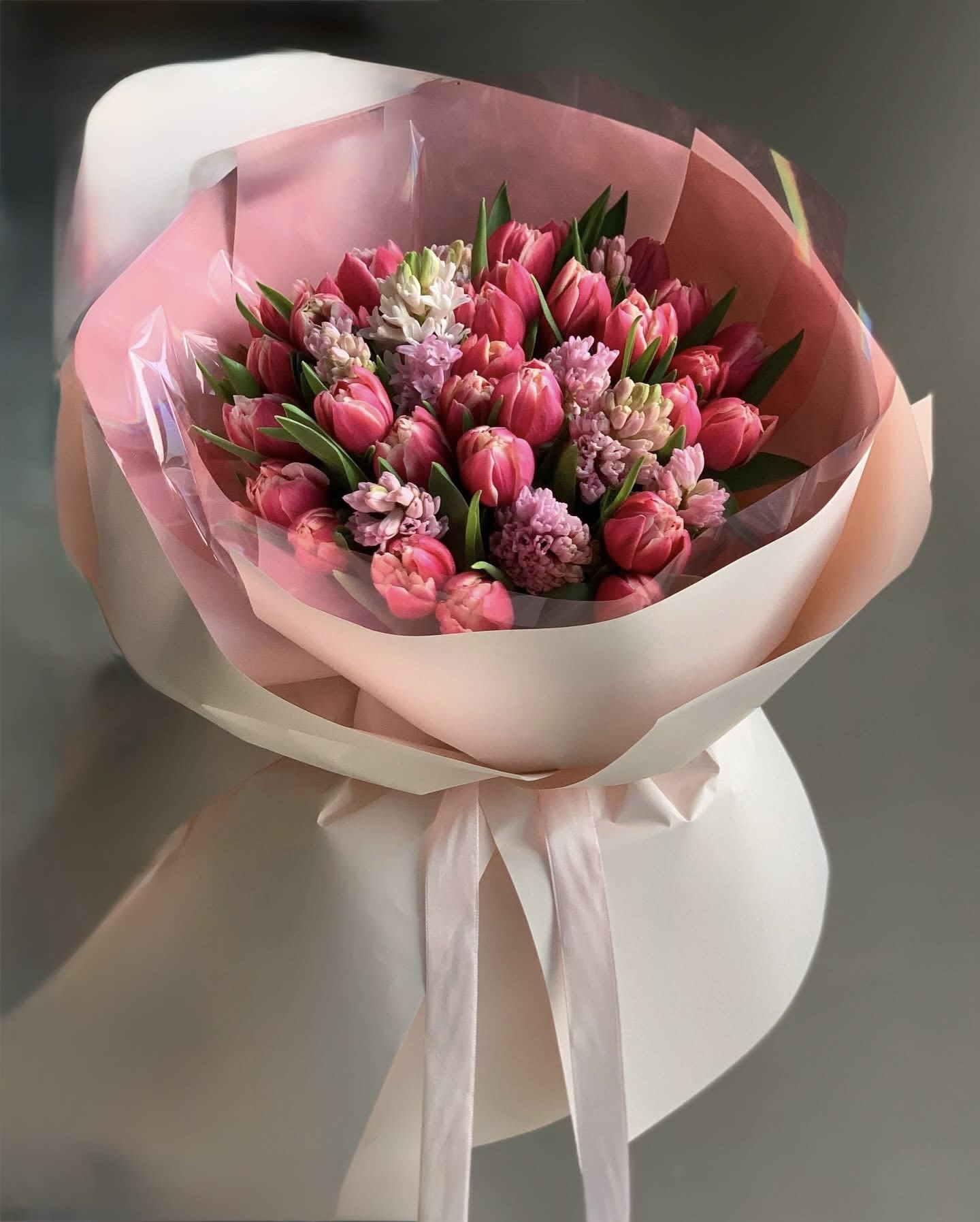 Pink tulip bouquet wrapped in pale pink paper with a ribbon