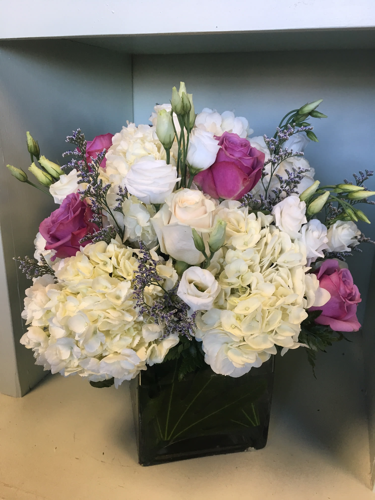 Bouquet of white hydrangeas and pink roses in a black vase