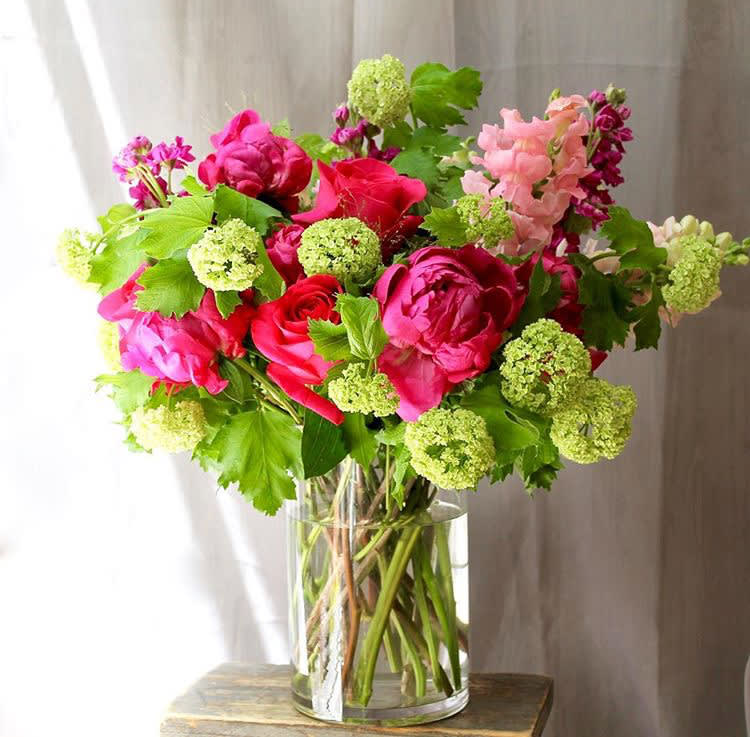 Bright pink and red bouquet in a clear glass vase