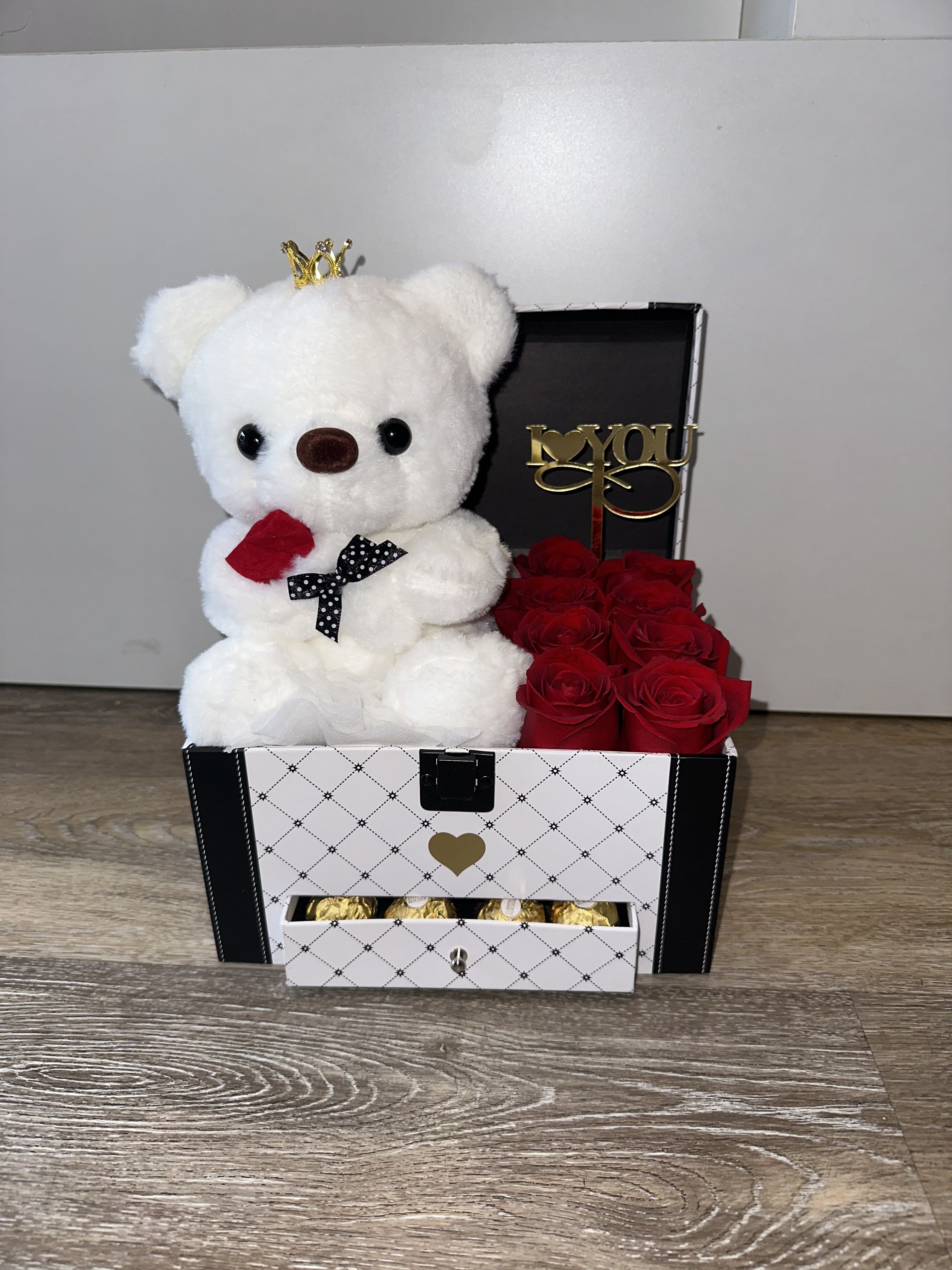 White teddy bear in a gift box with red roses and chocolates