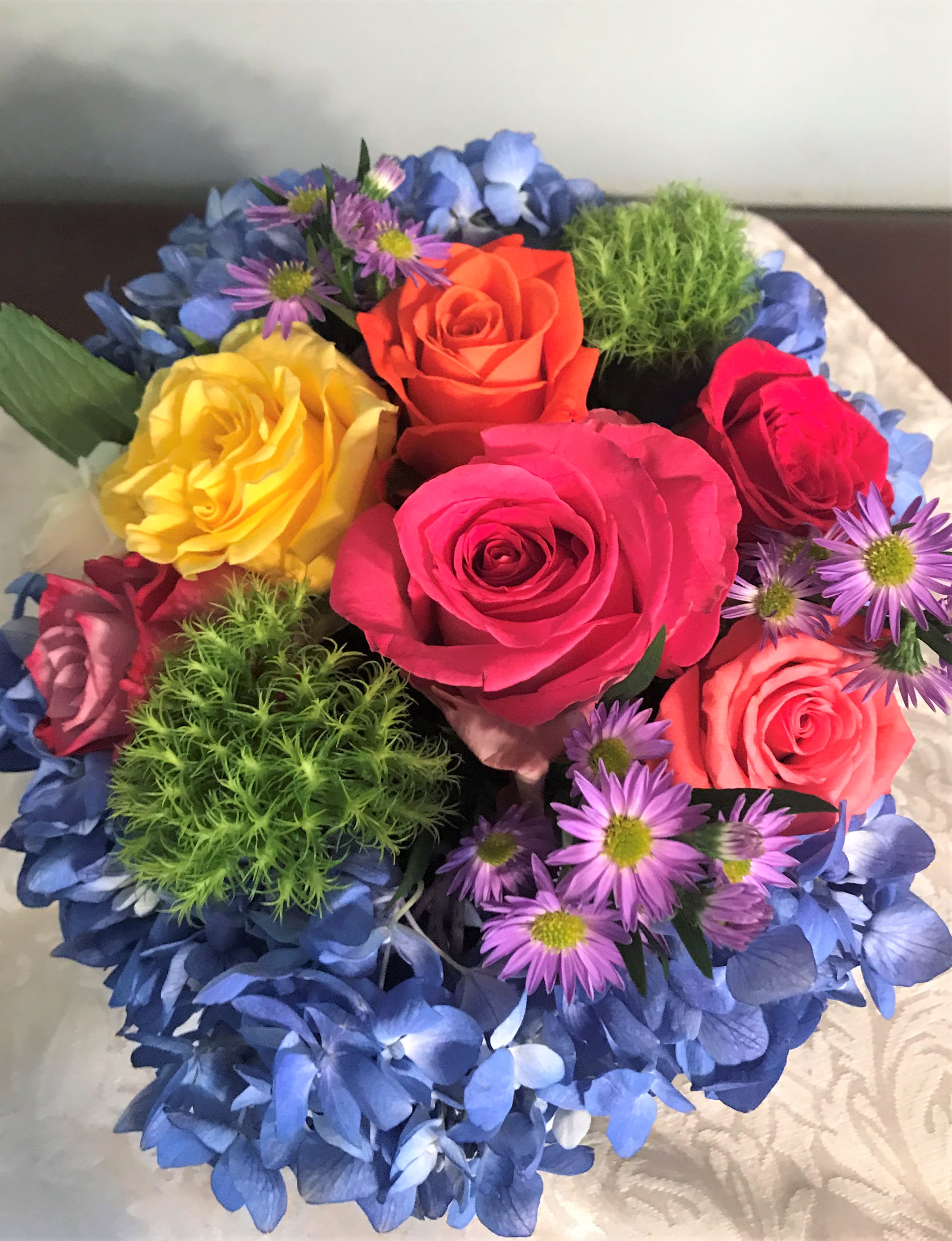 Colorful bouquet of roses and small purple daisies