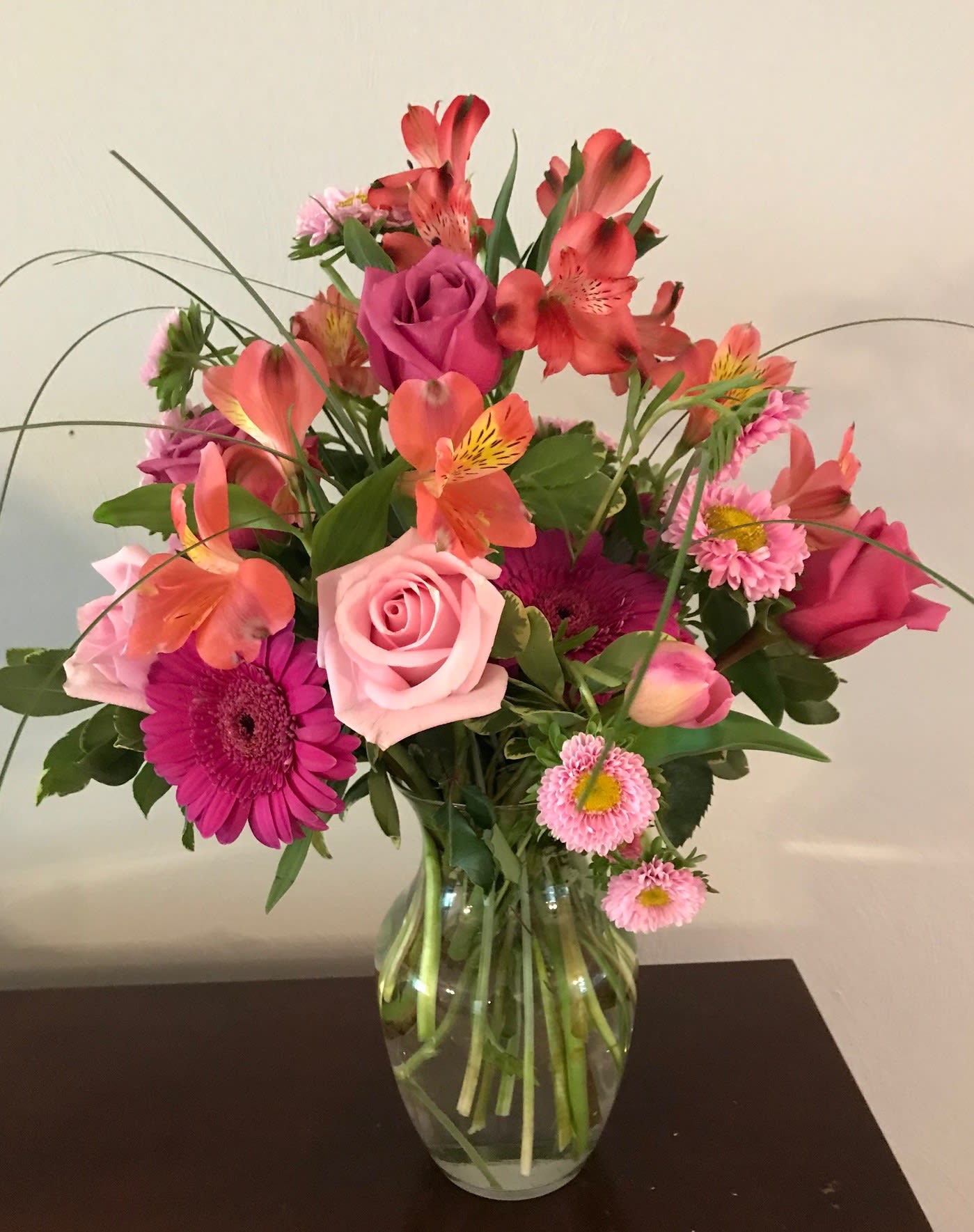 Pink and coral mixed bouquet in a clear glass vase