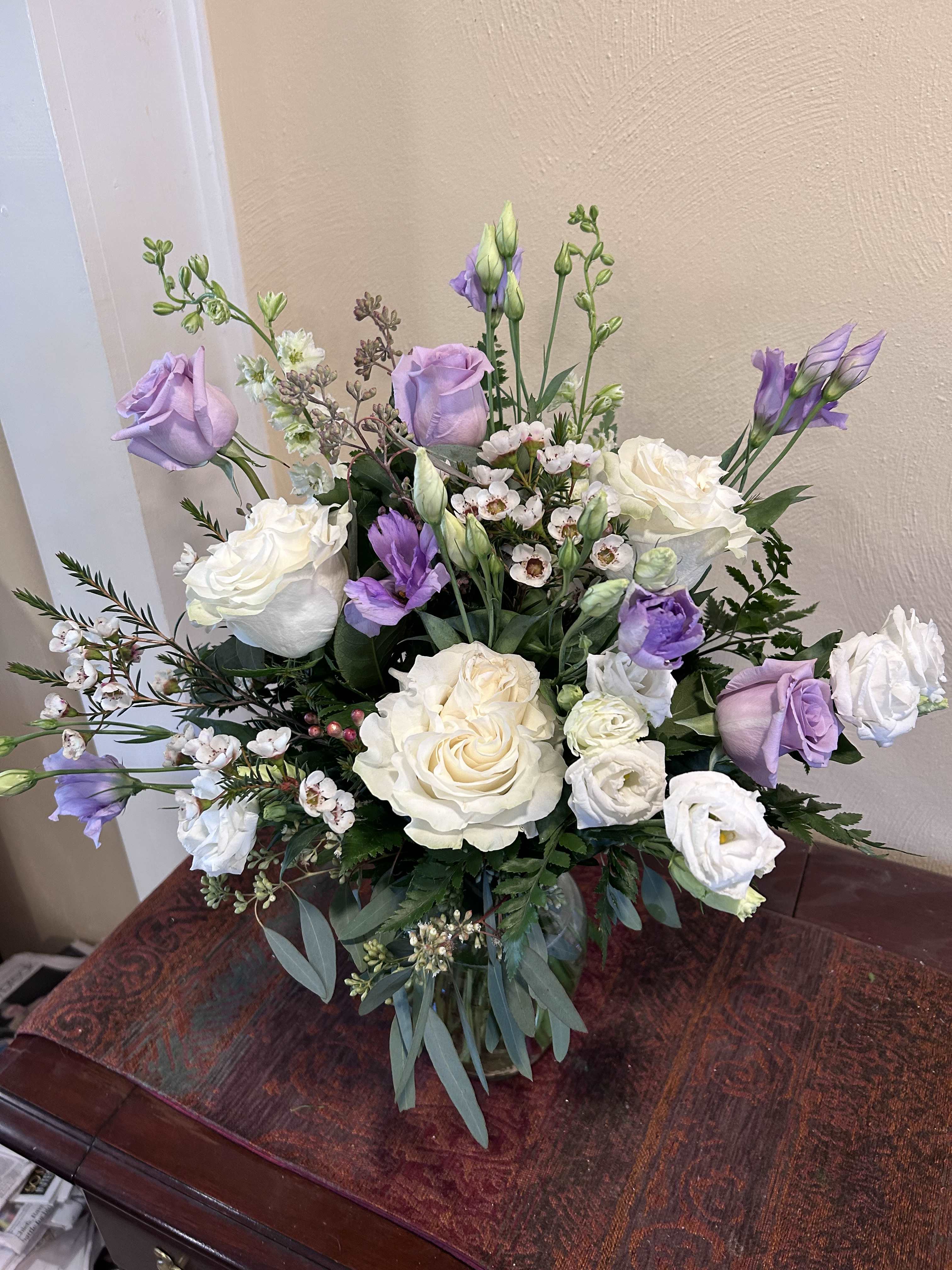 Lavender and white bouquet of roses and lisianthus in a glass vase