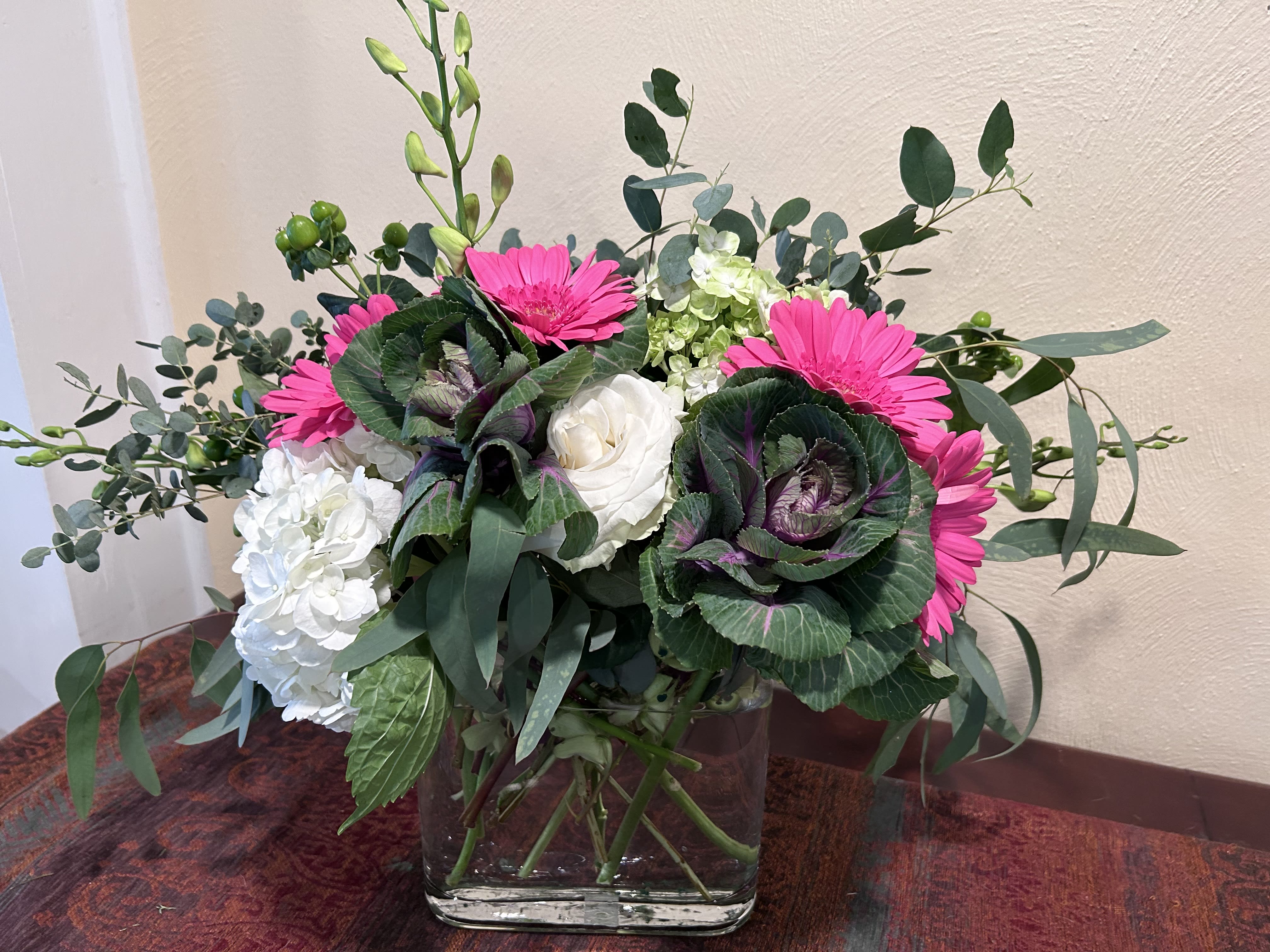 Unique Variations - Featuring ornamental kale, gerberas, and eucalyptus    Colors may vary