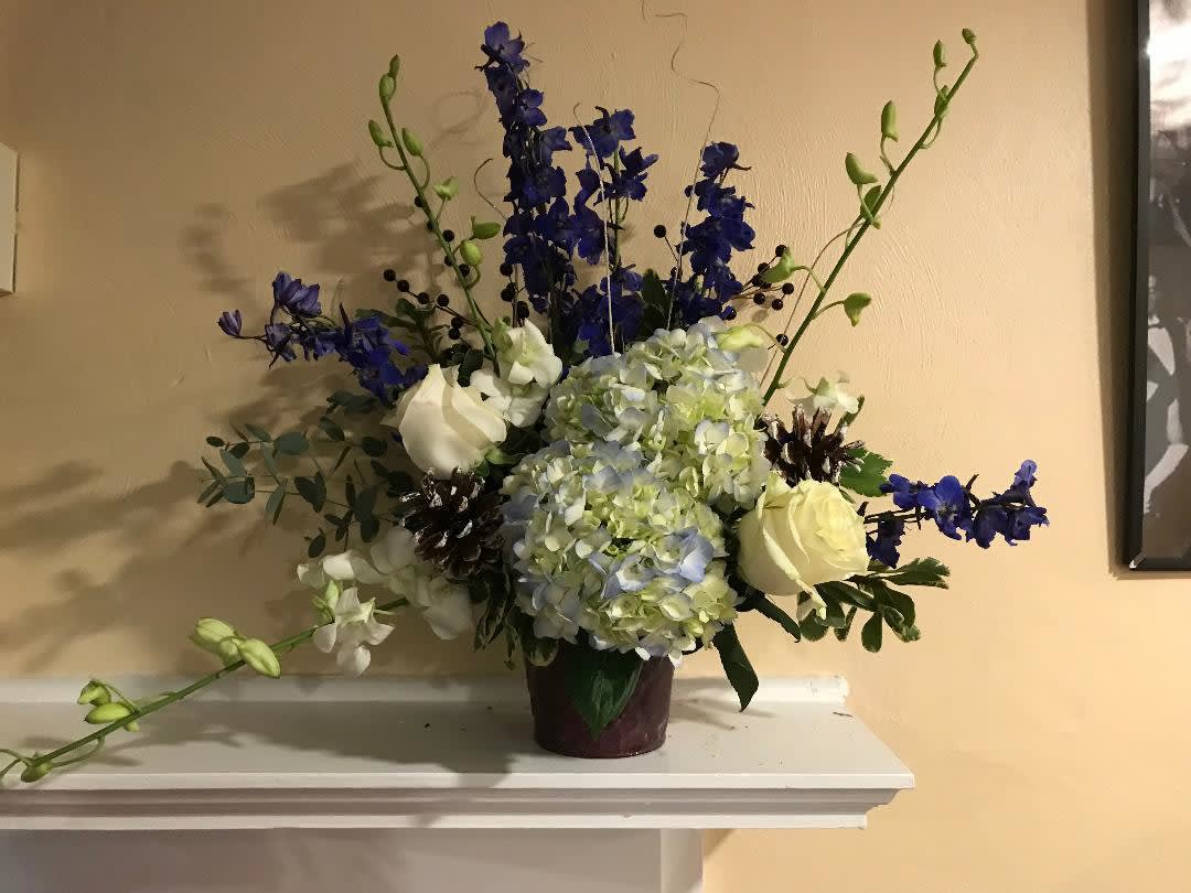 Blue and white floral arrangement in a dark vase
