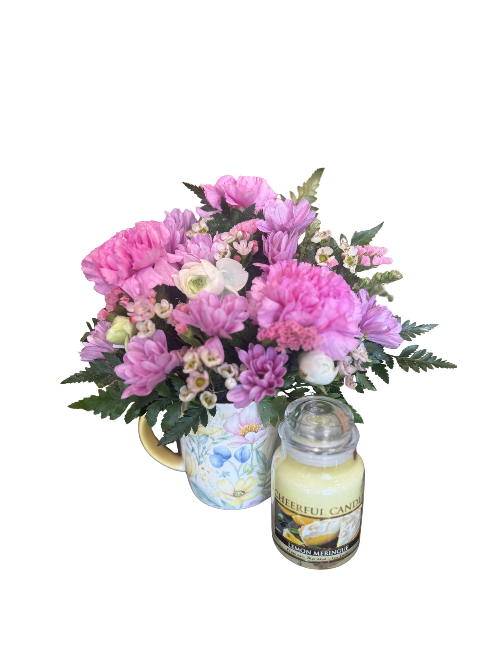 Pink mixed bouquet in a floral mug with a candle beside it