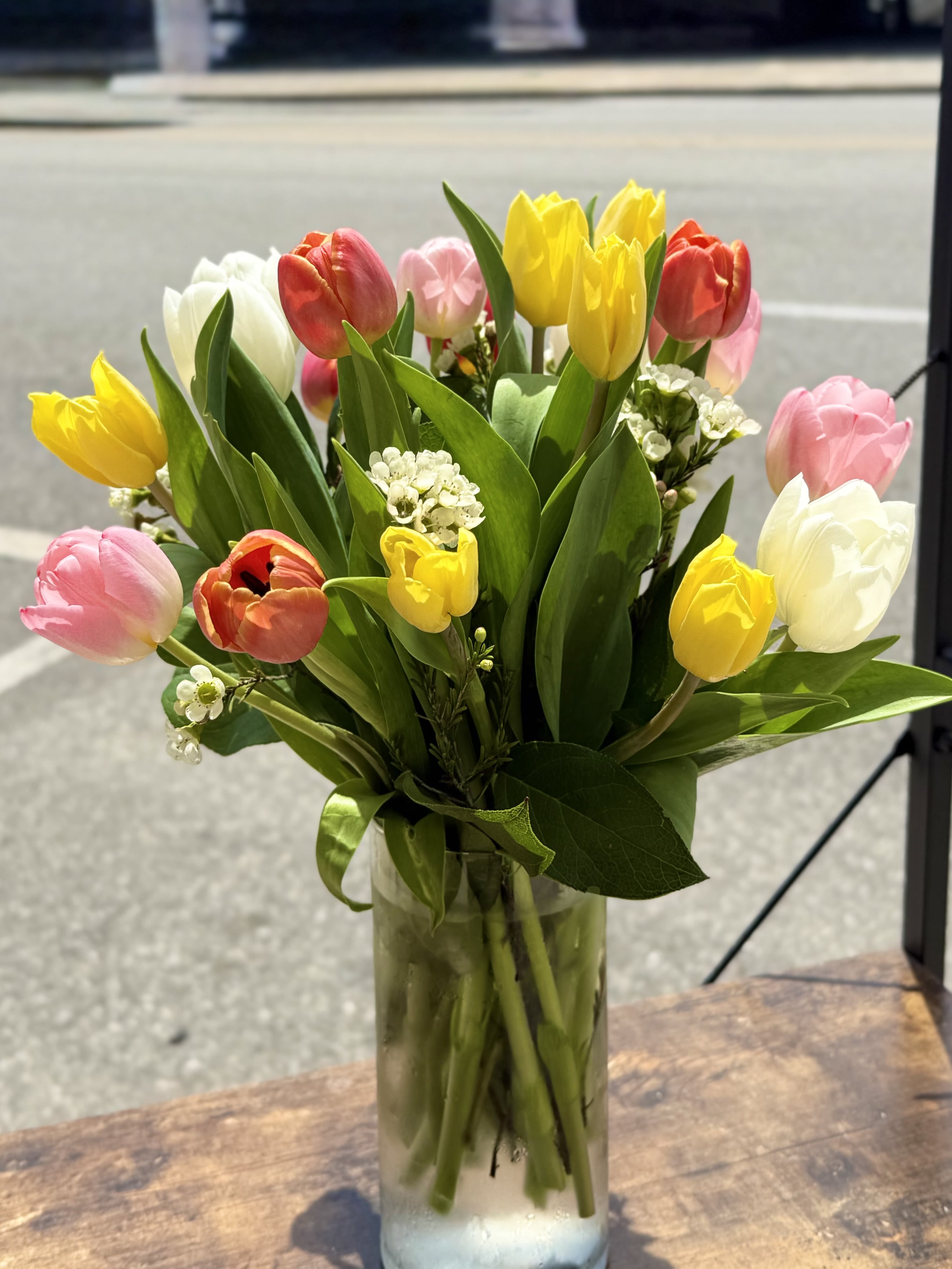Mixed tulips in pink, yellow, white, and red in a glass vase