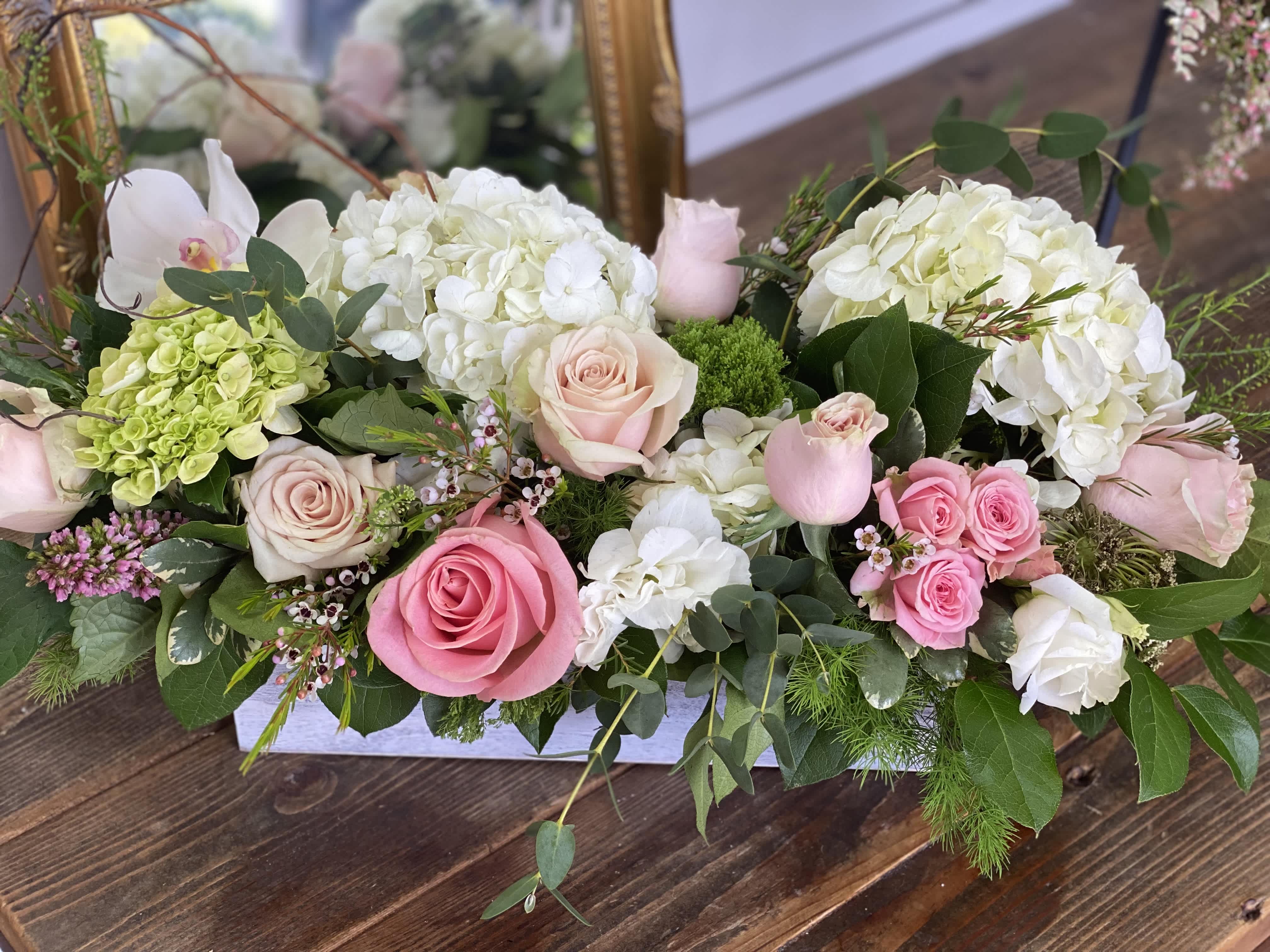 Pink and white roses with hydrangeas in a low rectangular arrangement