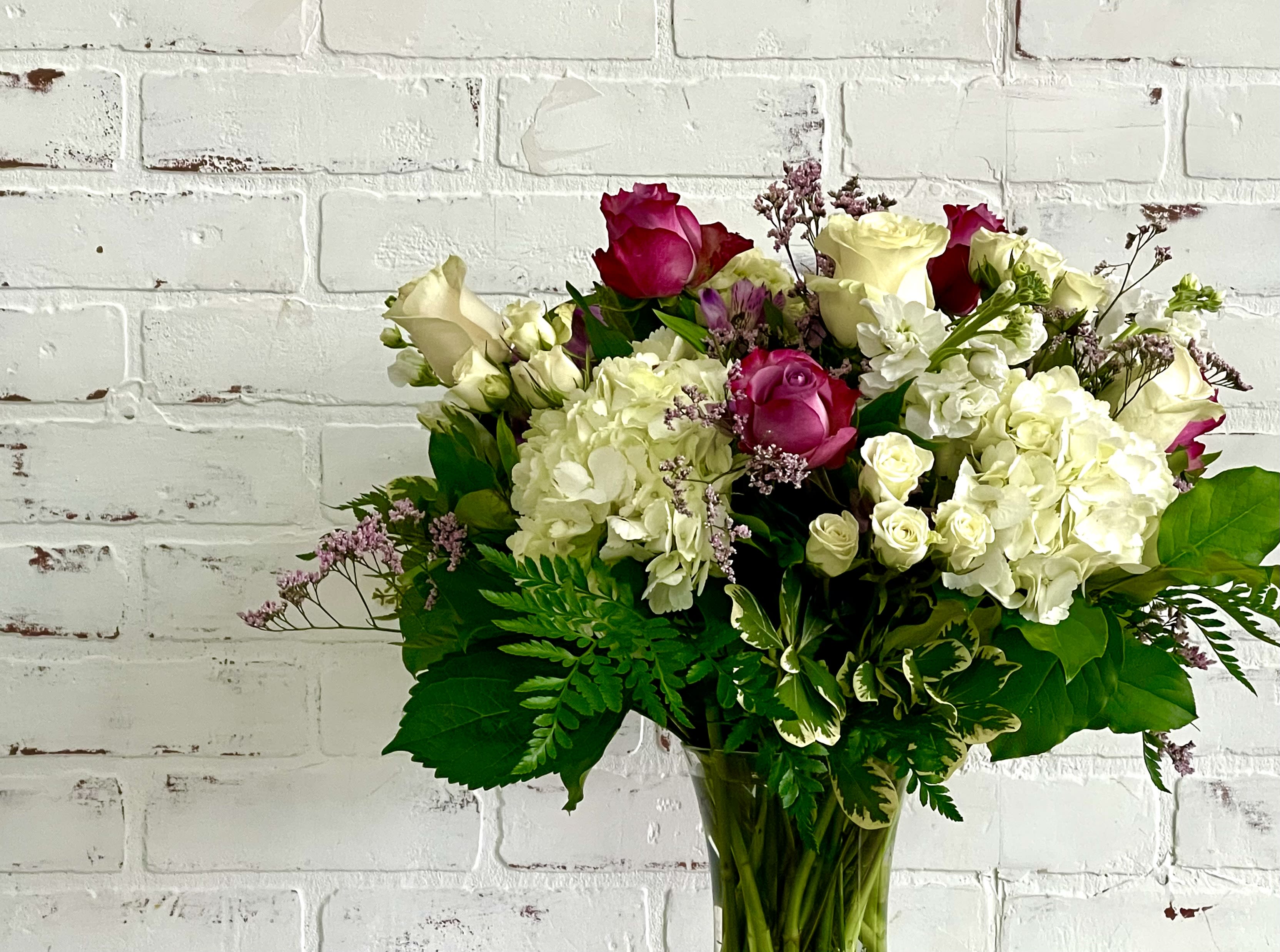 Bouquet of pink and white roses with hydrangeas in a glass vase