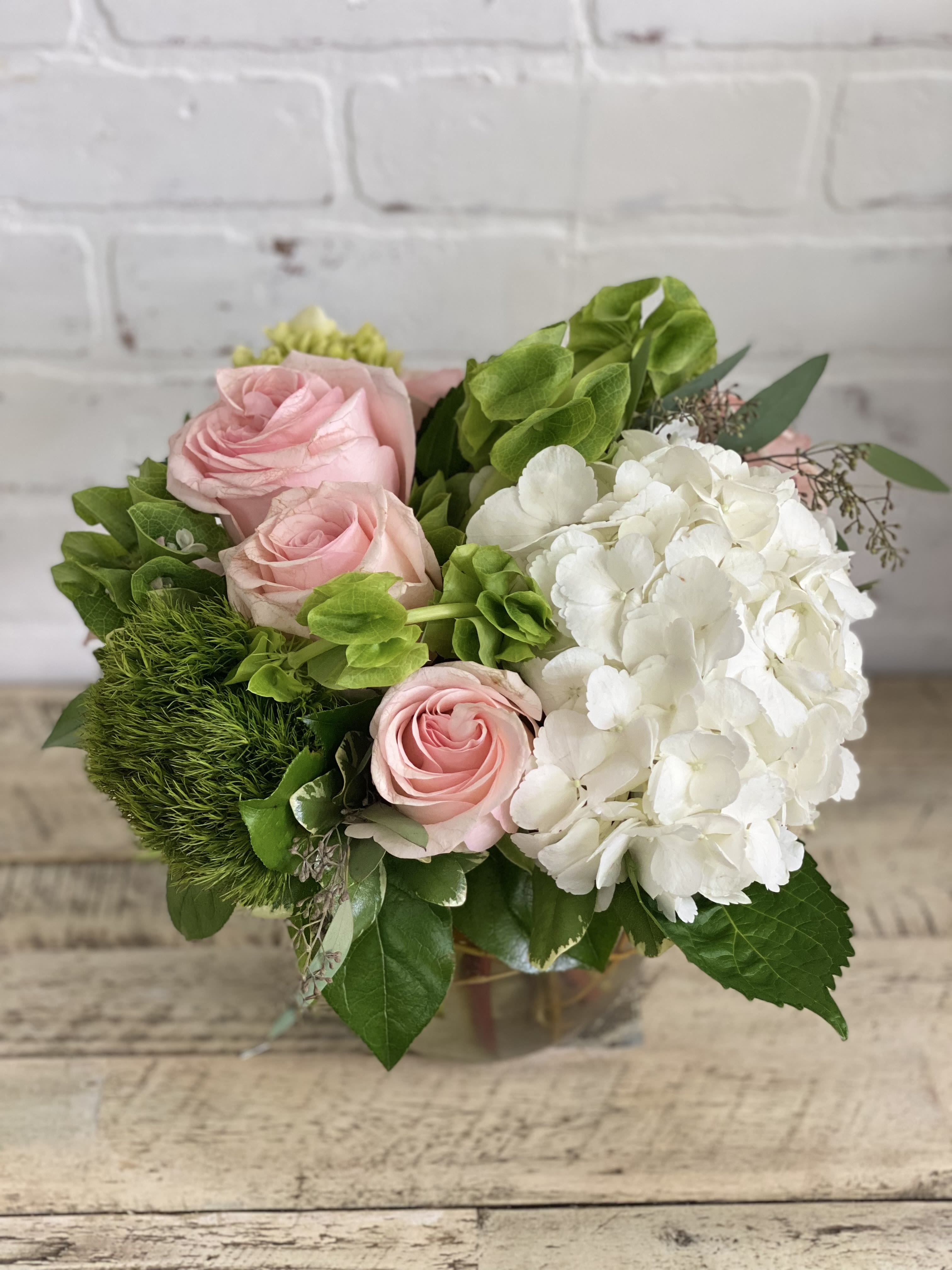 Pink roses and white hydrangea in a glass vase