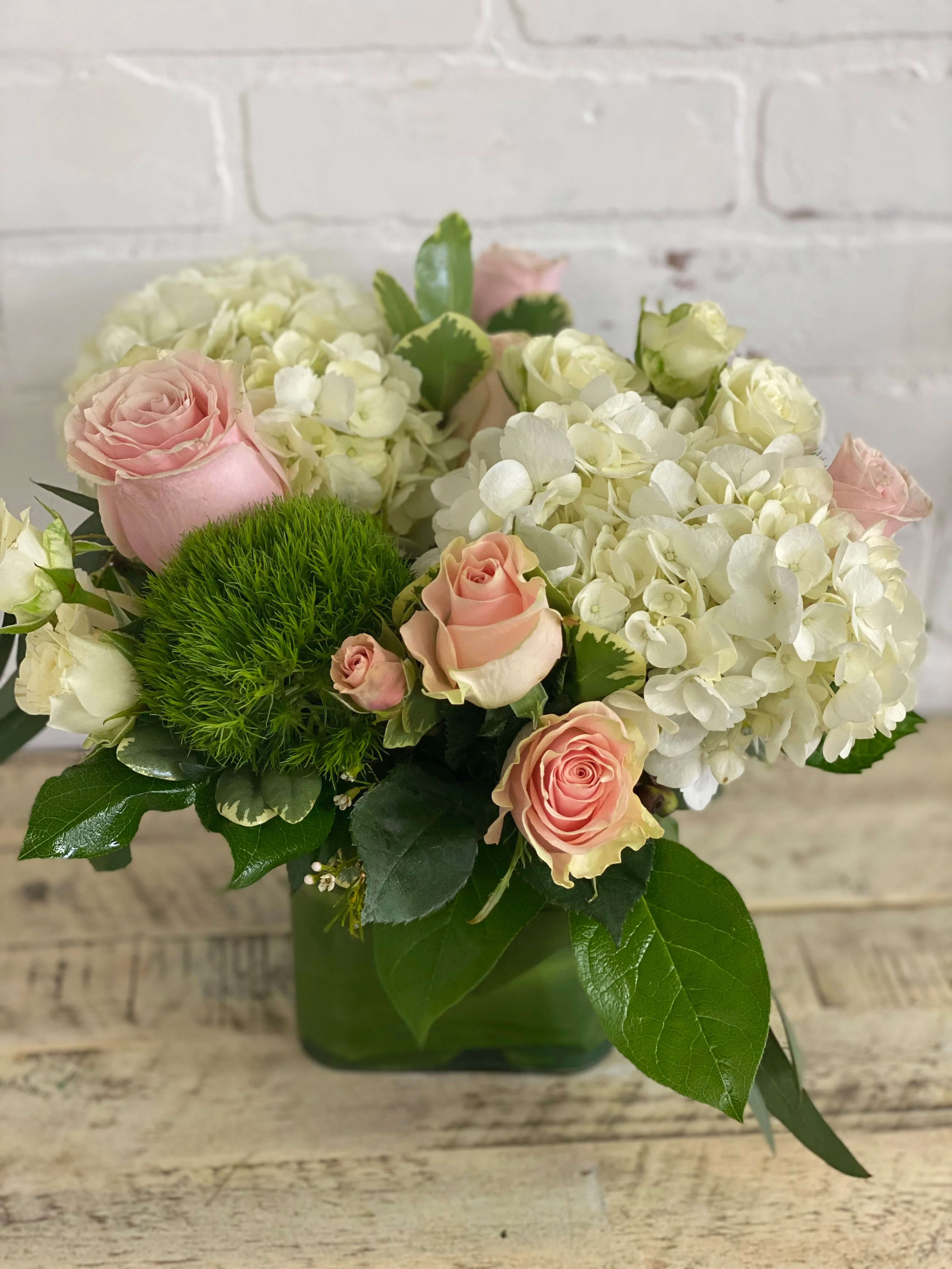 Pink roses and white hydrangeas in a green vase