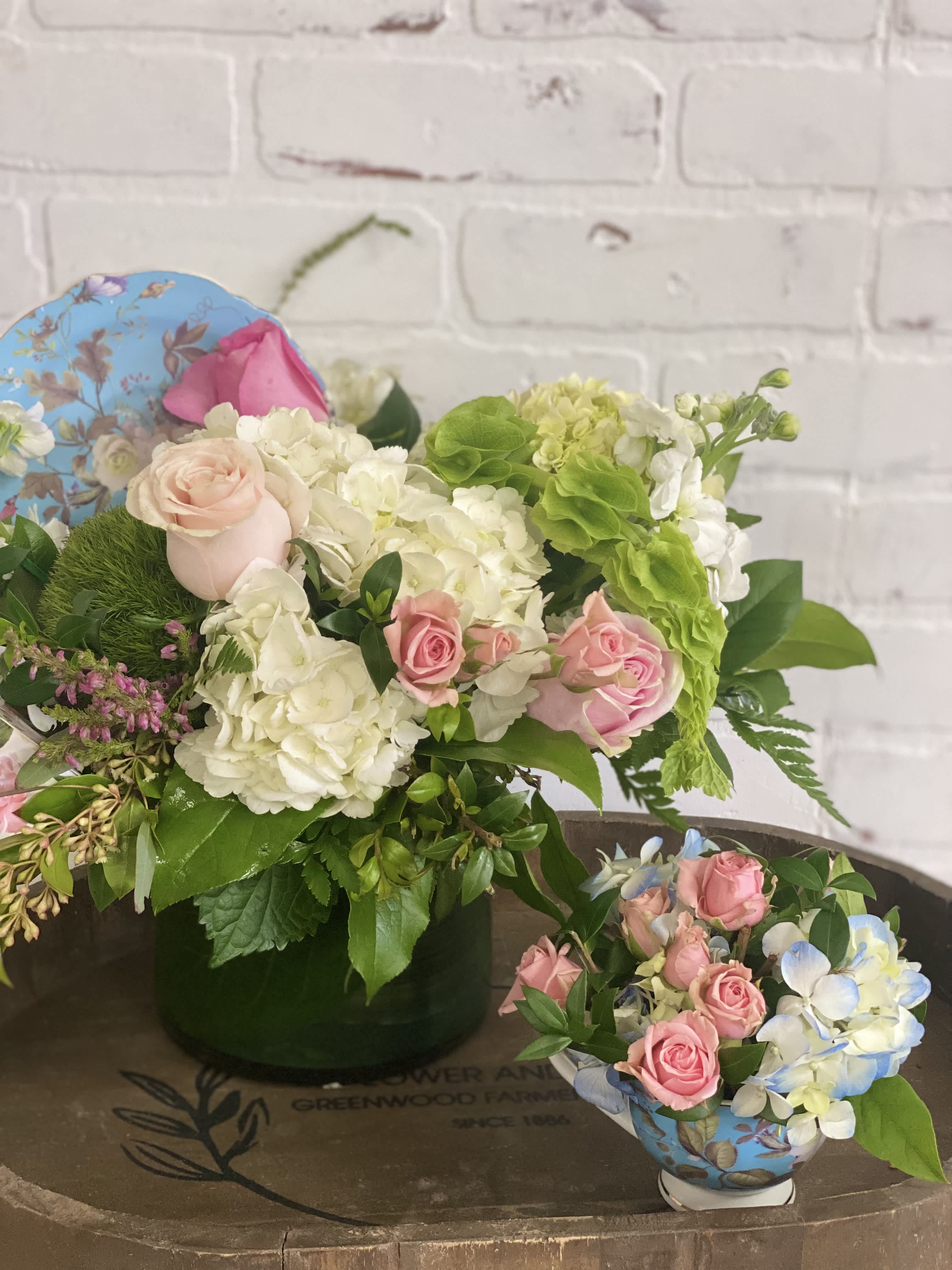 Pink roses and white hydrangeas arranged in a vase with greenery