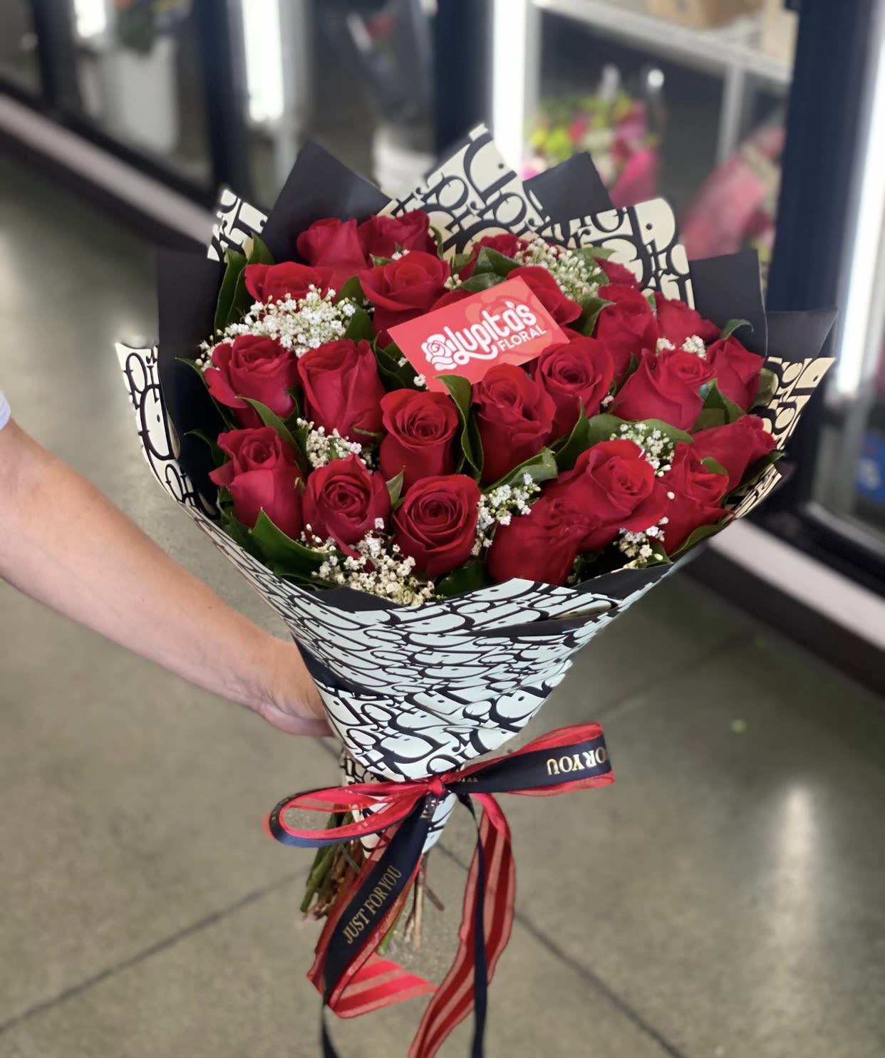 Bouquet of red roses wrapped in black-and-white paper