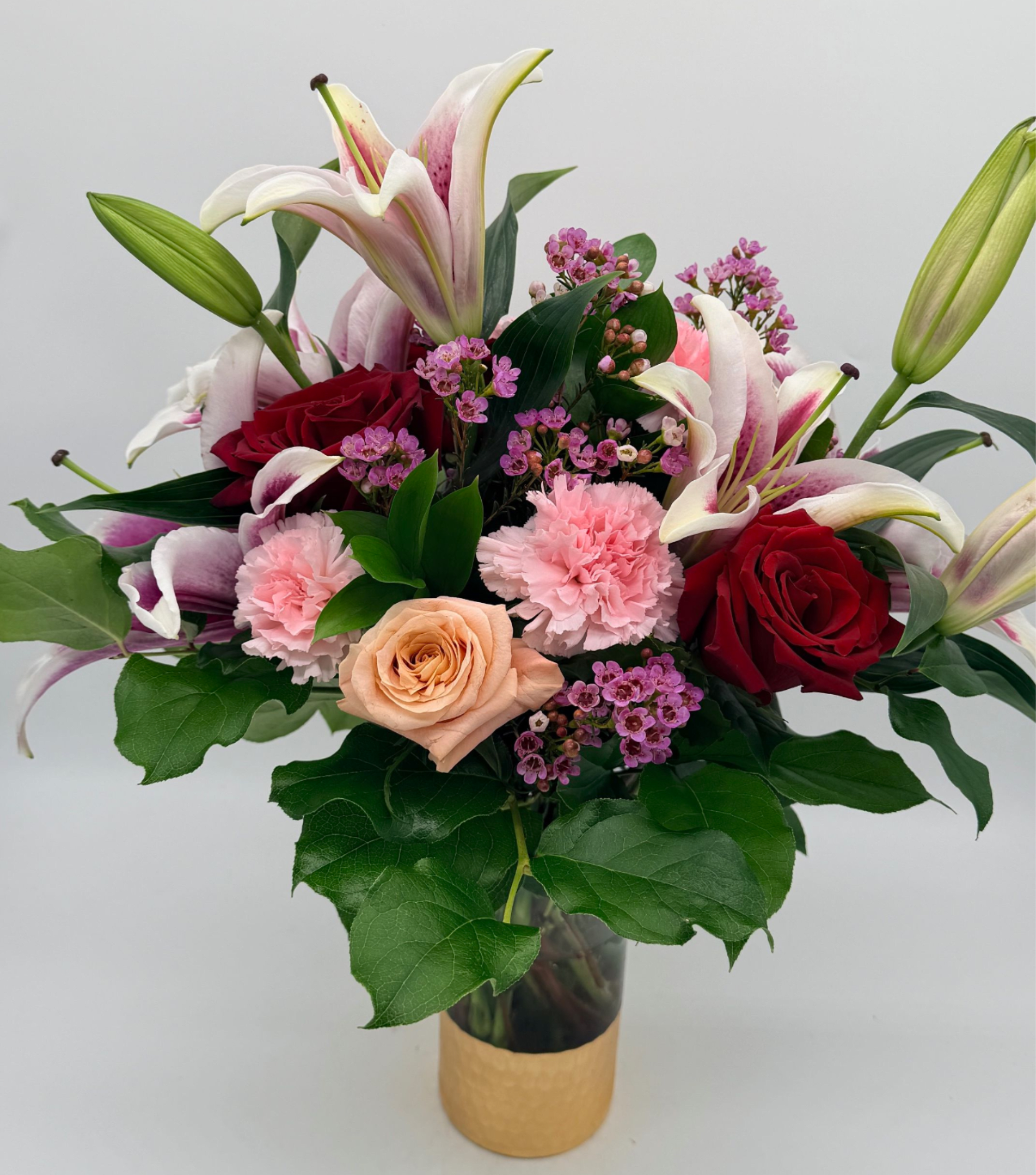 Swooning over you - A swoon-worthy arrangement that speaks the language of love, roses, lilies, and carnations. Flower varieties/shades and accent blooms may vary slightly based on availability, but the look and feel will always remain full, bright, and joyful.
