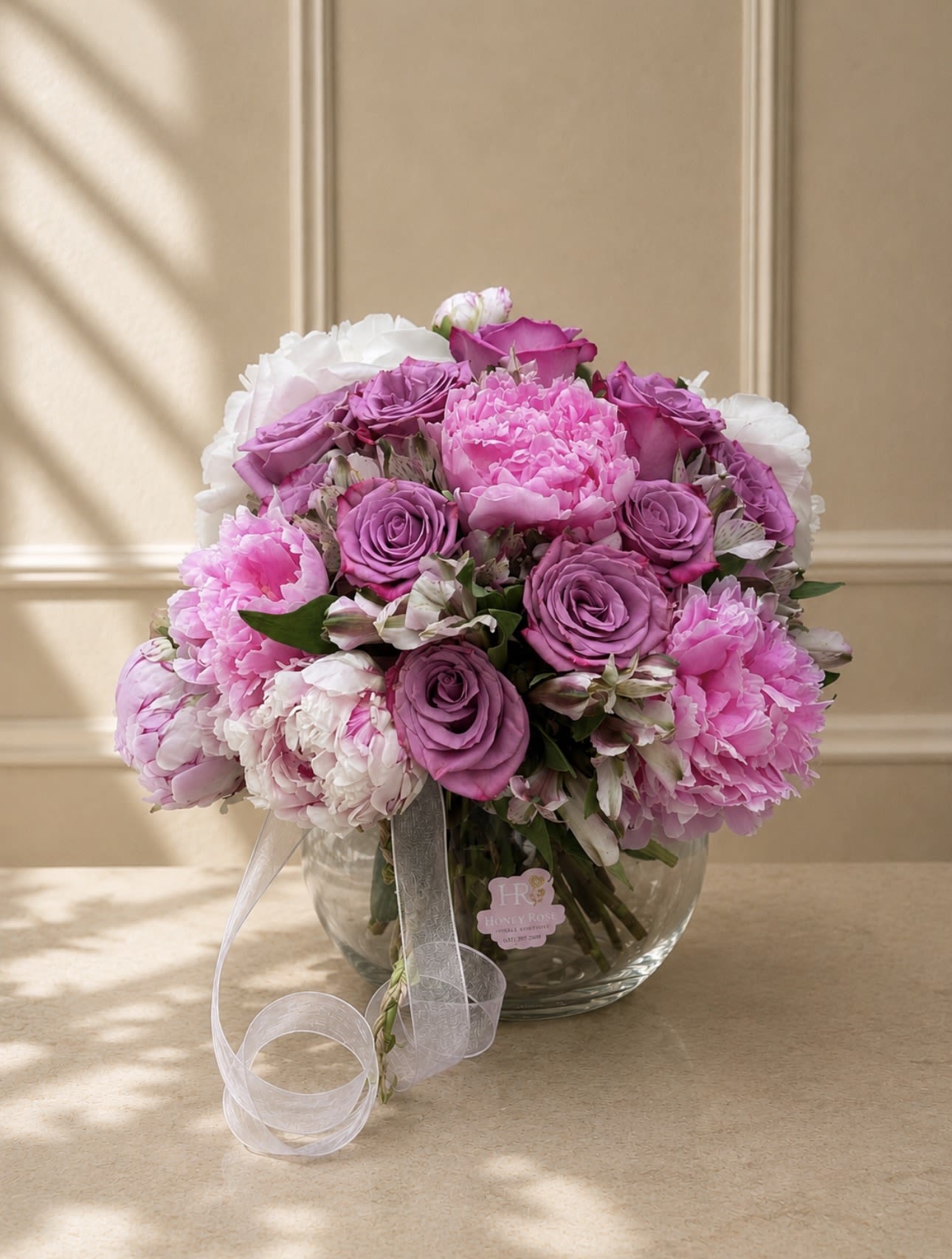 Peony Blush Garden - A romantic and elegant arrangement featuring lush pink peonies, lavender roses, alstroemeria, and soft seasonal blooms in a modern glass vase. Designed with delicate textures and soft feminine tones, this arrangement is perfect for Mother’s Day, birthdays, and luxury gifting.