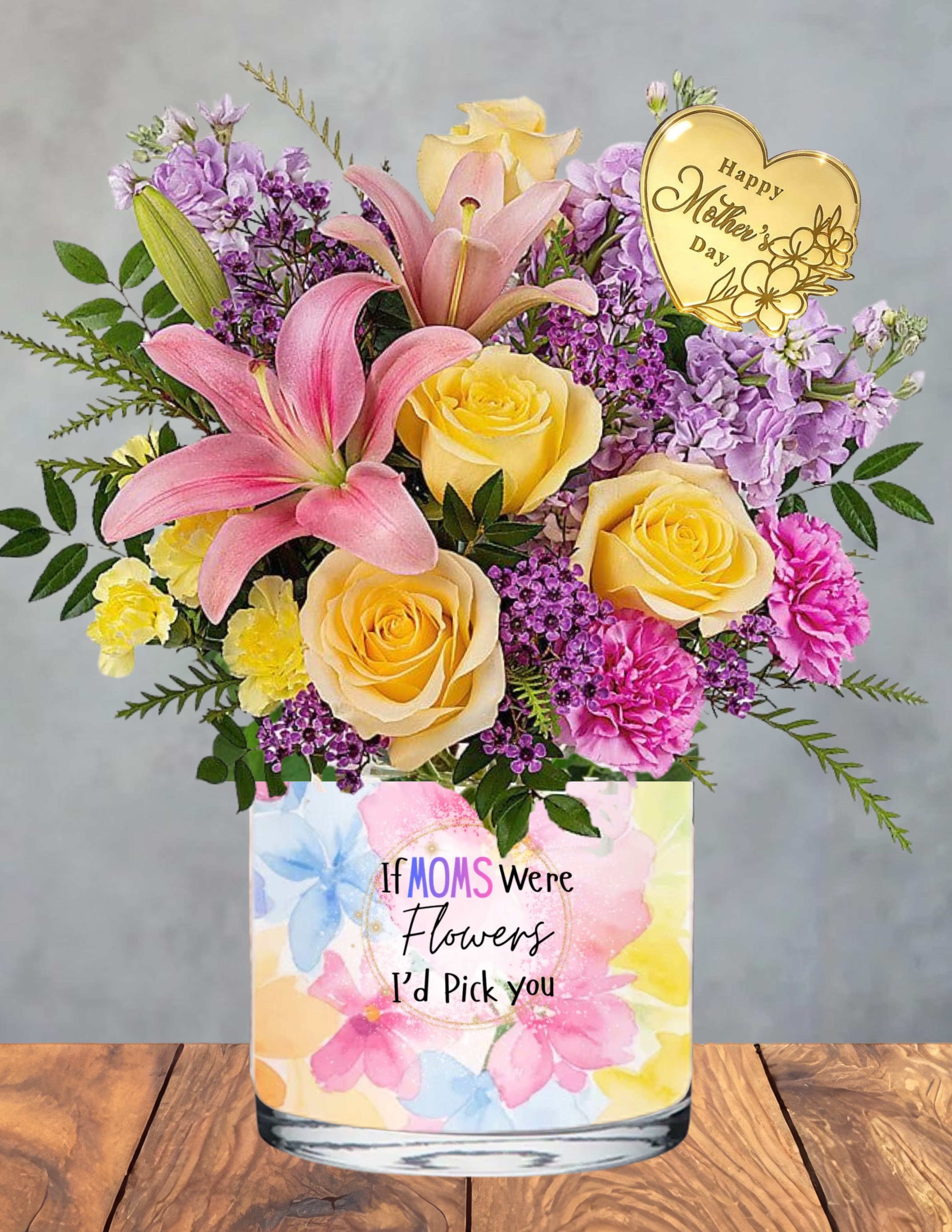 Cherished mom - A gentle, glowing tribute to the woman who holds everything together with love.  Cherished Mom blends soft pink lilies, sunny yellow roses, and delicate purple blooms into a tender, uplifting embrace. Each flower is chosen for its symbolism — admiration, gratitude, and the quiet strength only a mother carries. Nestled at the heart of the arrangement is a gold‑engraved keepsake, adding a touch of elegance and sentiment that makes this bouquet feel truly special.  Presented in a pastel floral vase adorned with the message “If Moms Were Flowers, I’d Pick You,” this design radiates warmth, appreciation, and heartfelt devotion. It’s a beautiful way to honor her presence, her kindness, and the countless ways she makes life bloom.