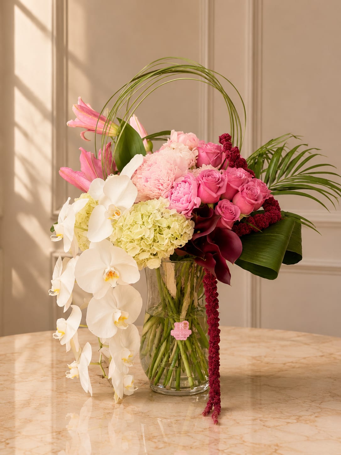  Orchid Bliss - A luxurious floral arrangement featuring cascading orchids, premium roses, hydrangeas, and tropical greenery designed for a modern and elegant statement.