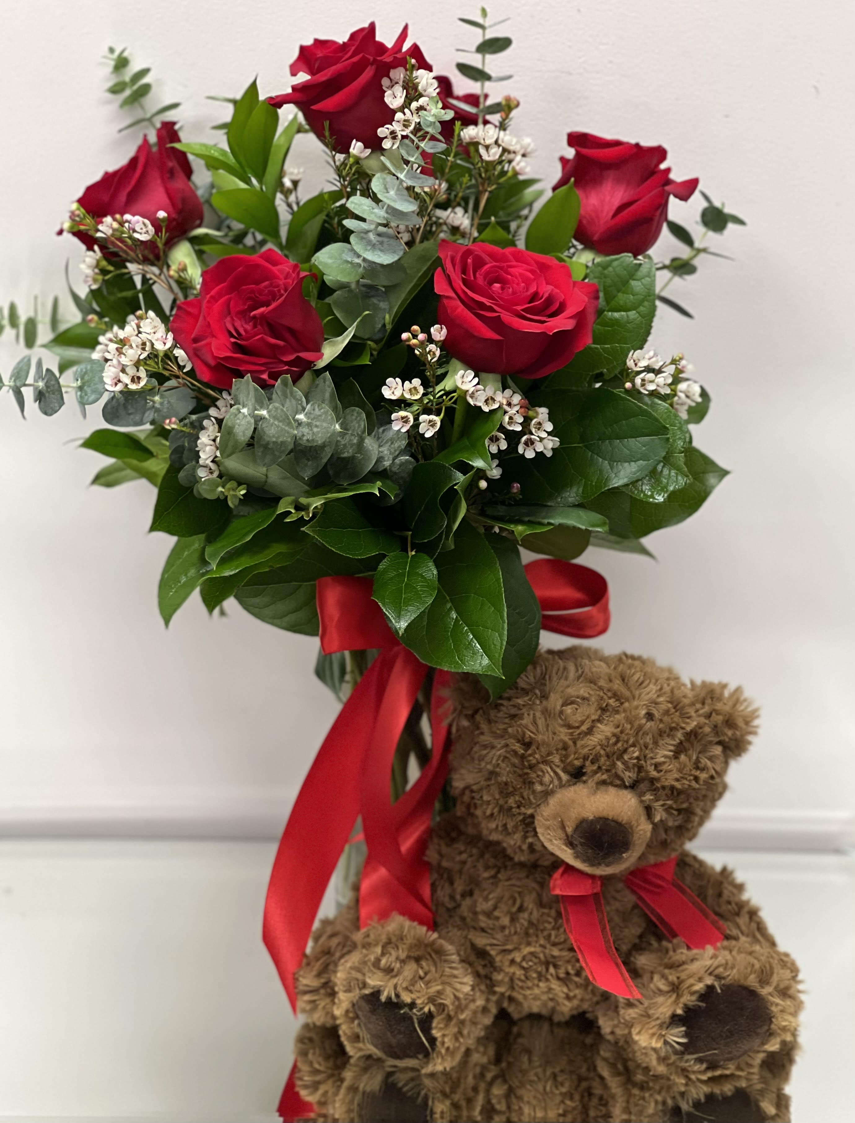 Red rose bouquet with a teddy bear and red ribbon