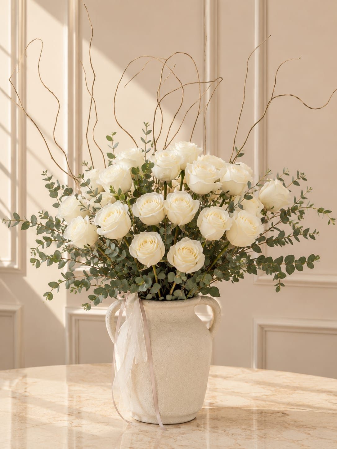 White Rose Elegance - A sophisticated design featuring premium white roses, fresh eucalyptus, and natural branches styled in a modern ceramic vase for a soft and luxurious look.