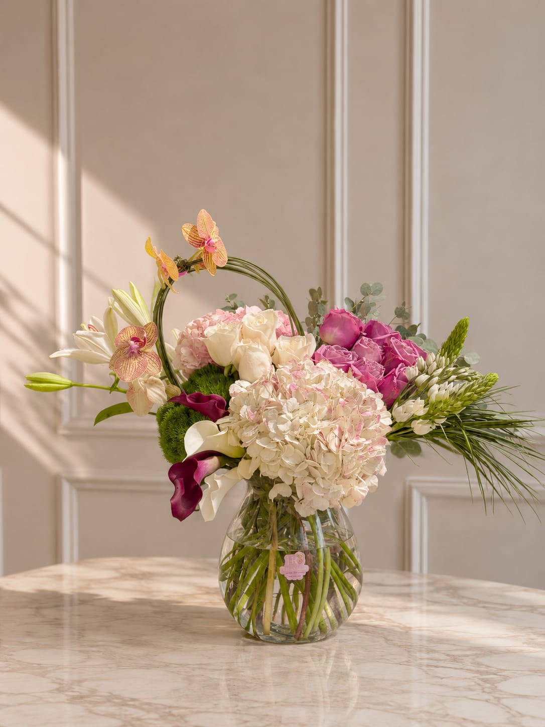 Butterfly Dream - A romantic mix of orchids, roses, hydrangeas, and seasonal blooms in soft blush and ivory tones, designed in a clear glass vase.
