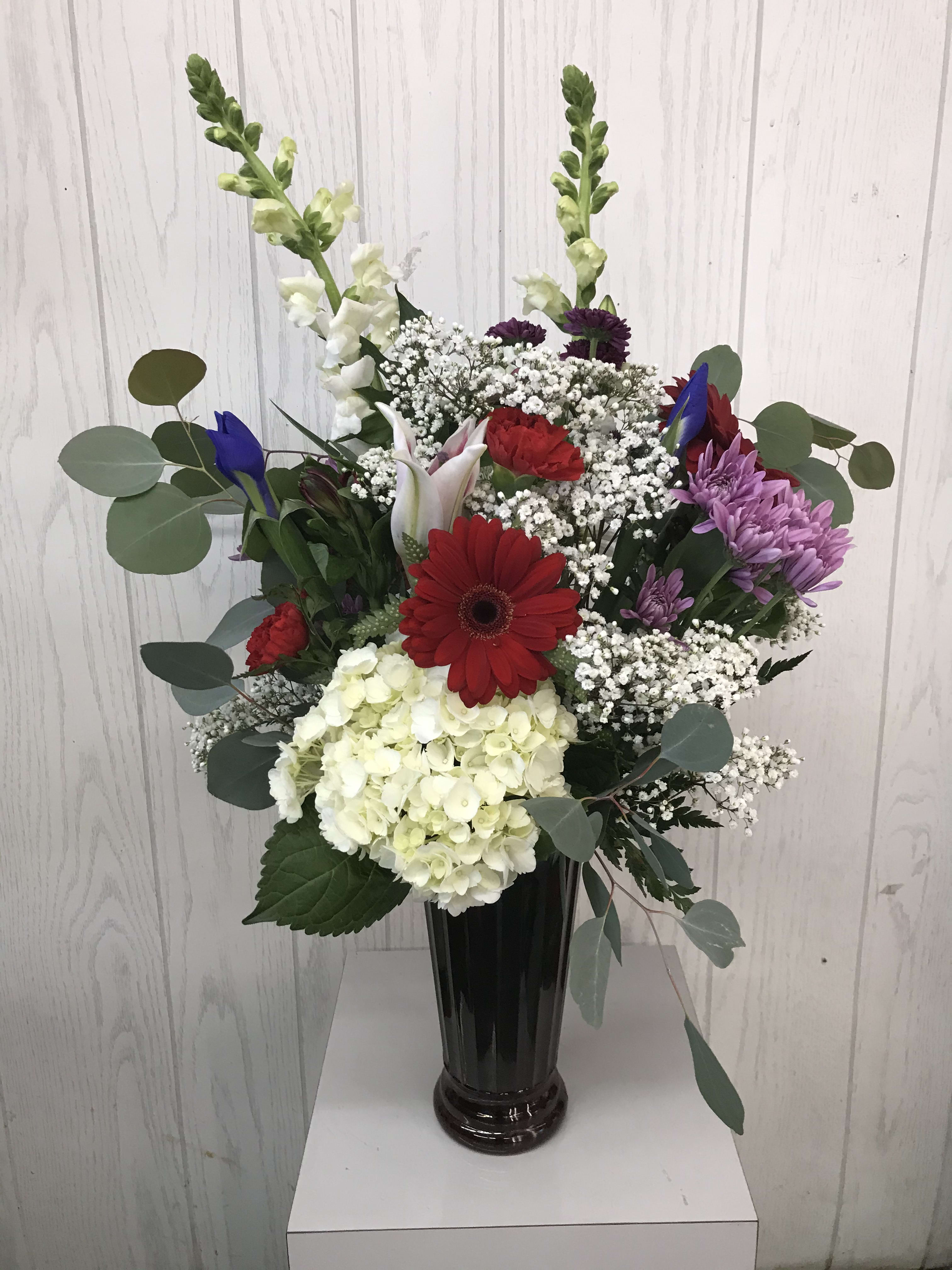 Mixed bouquet in a black vase with red, white, and purple flowers